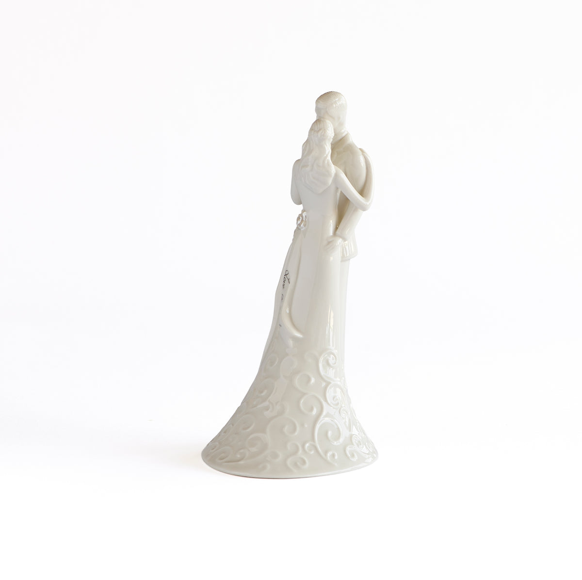 Side view of porcelain wedding couple highlighting the bride’s long gown and sweeping train.