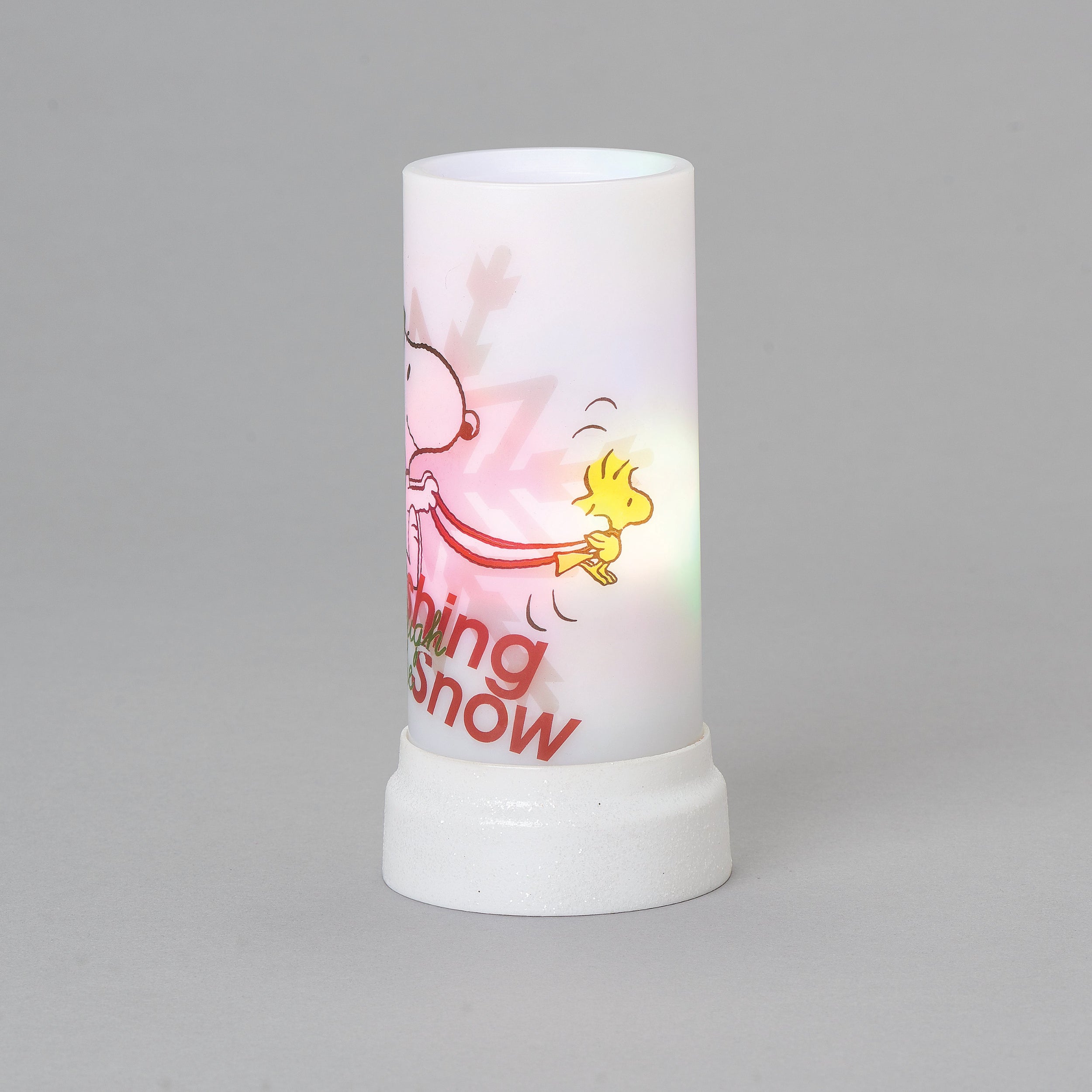 Candle with cartoon design and text on a gray background