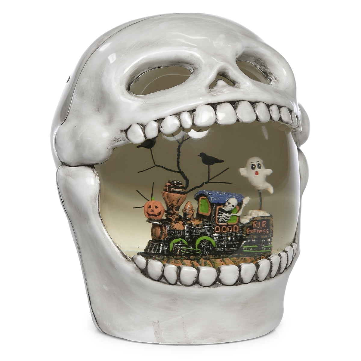Front angled view of skull decoration showing hollow eye sockets and the Halloween train scene between its teeth.