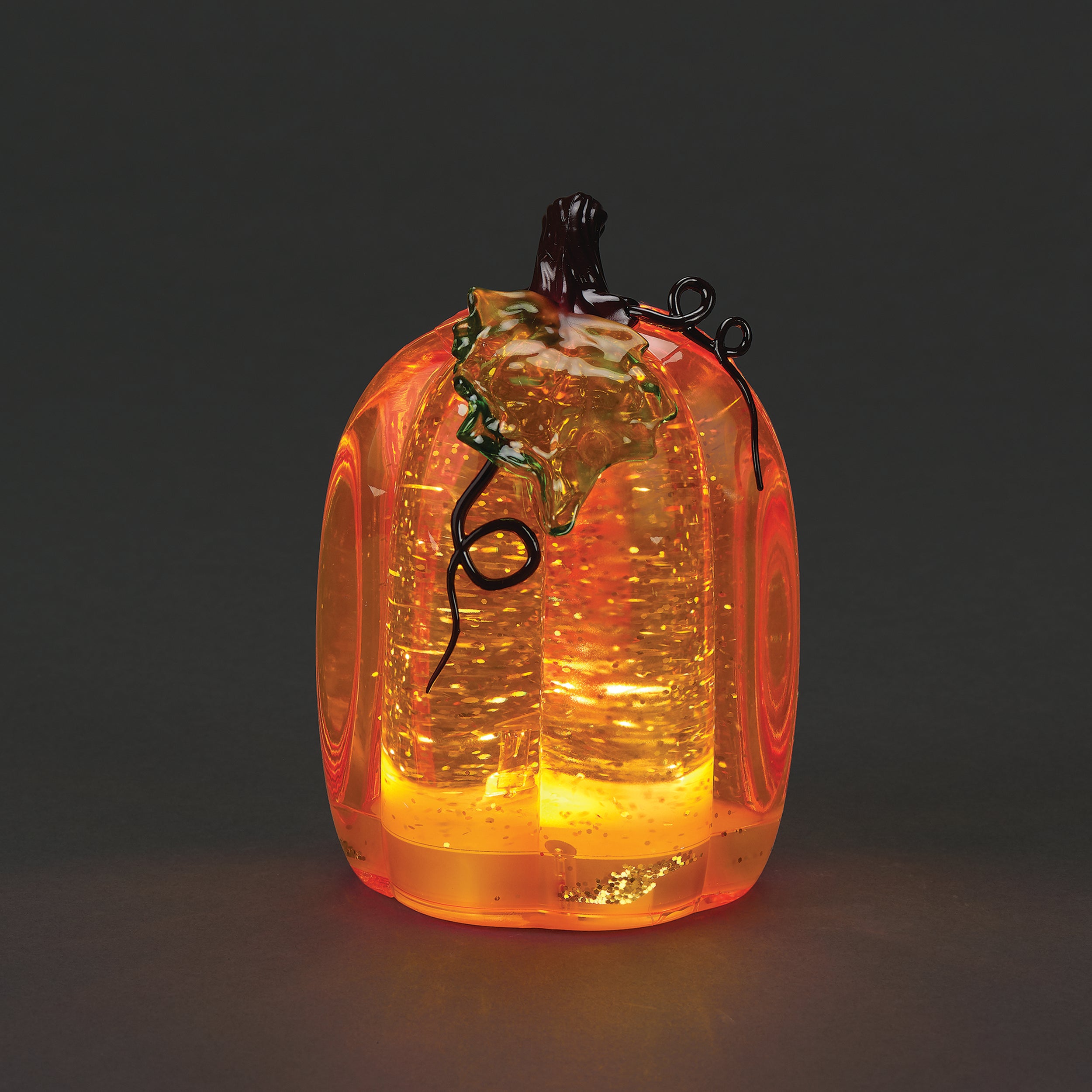 Glass pumpkin with glowing interior on a dark background