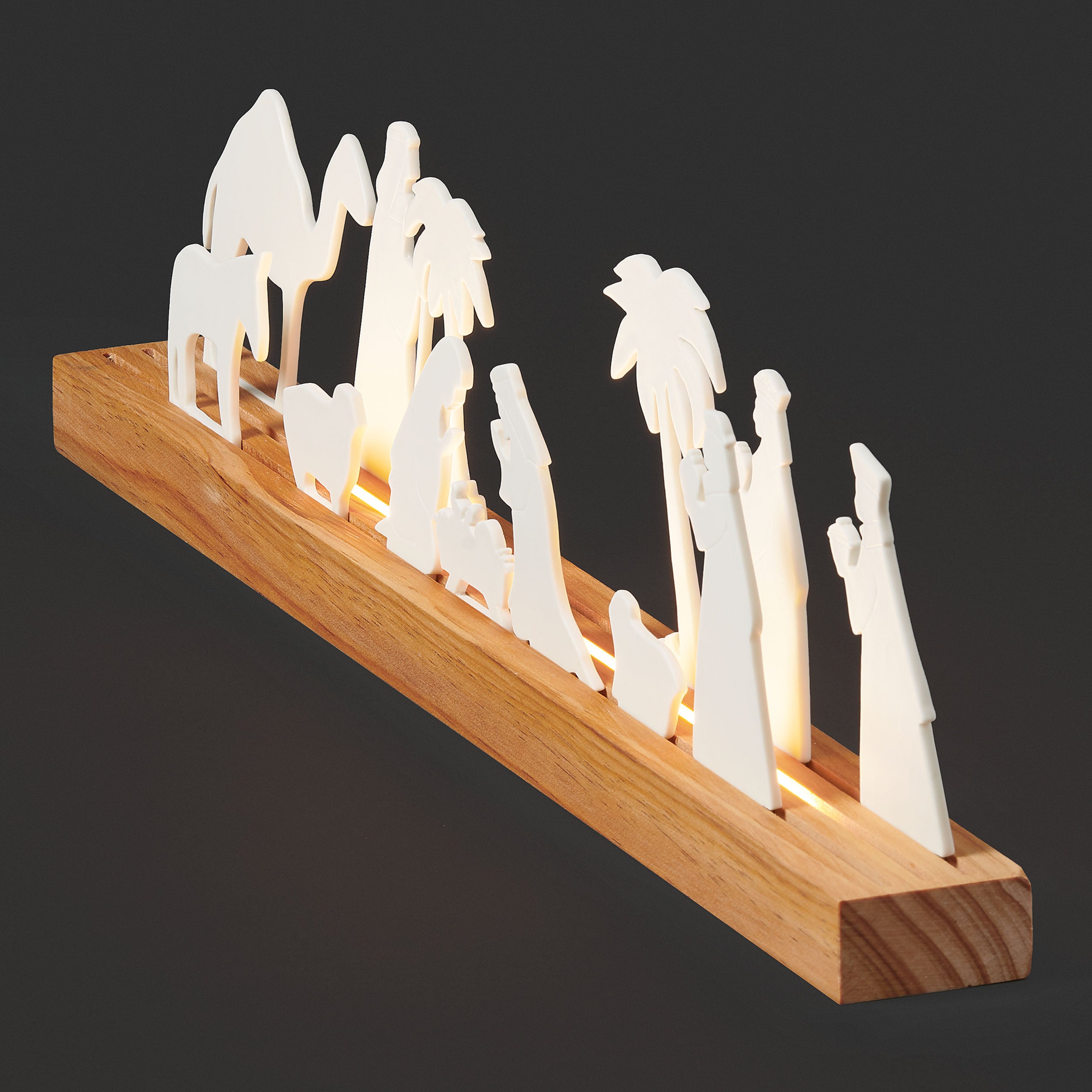 Silhouette nativity scene with wooden base on a black background