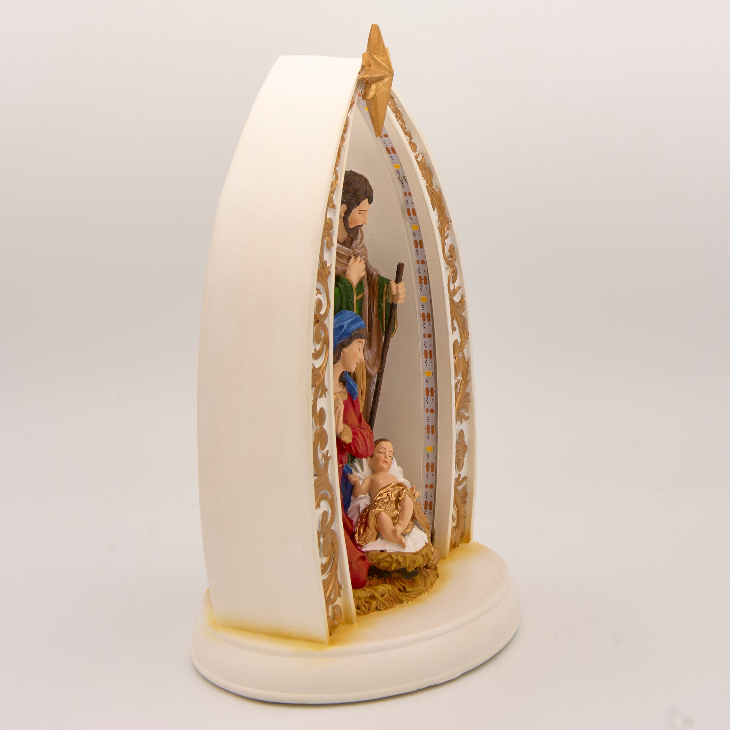 Decorative nativity scene with Mary, Joseph, and baby Jesus in a starlit arch.
