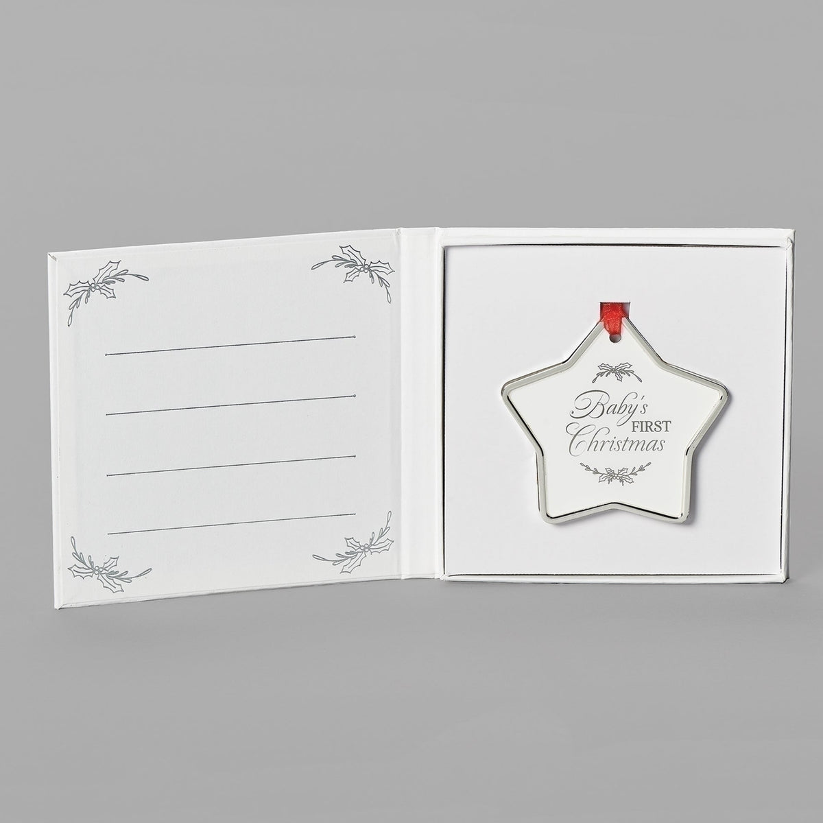 Open keepsake packaging showing the Baby’s First Christmas star ornament beside a printed message.