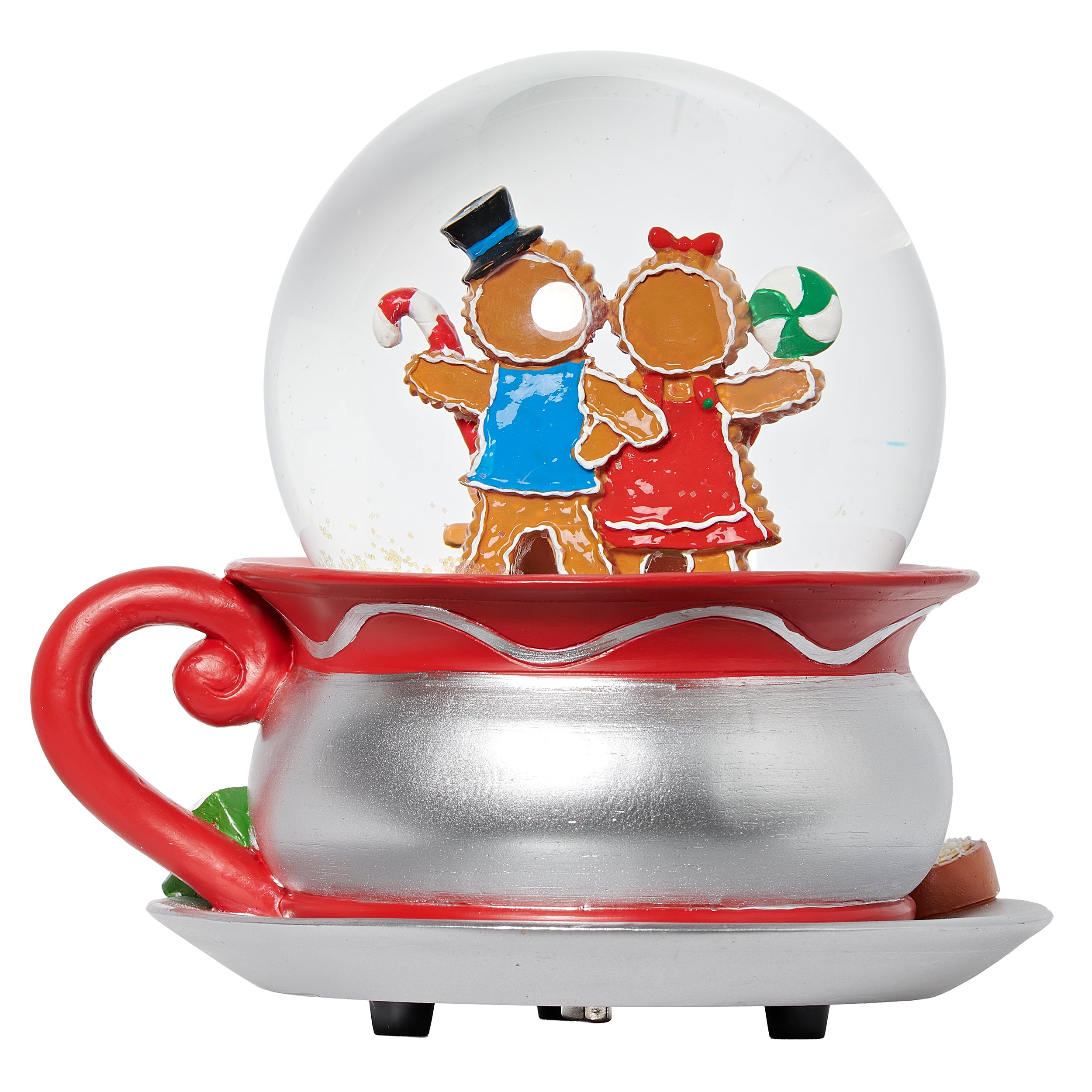 Decorative snow globe with gingerbread people inside, placed on a red and silver base.