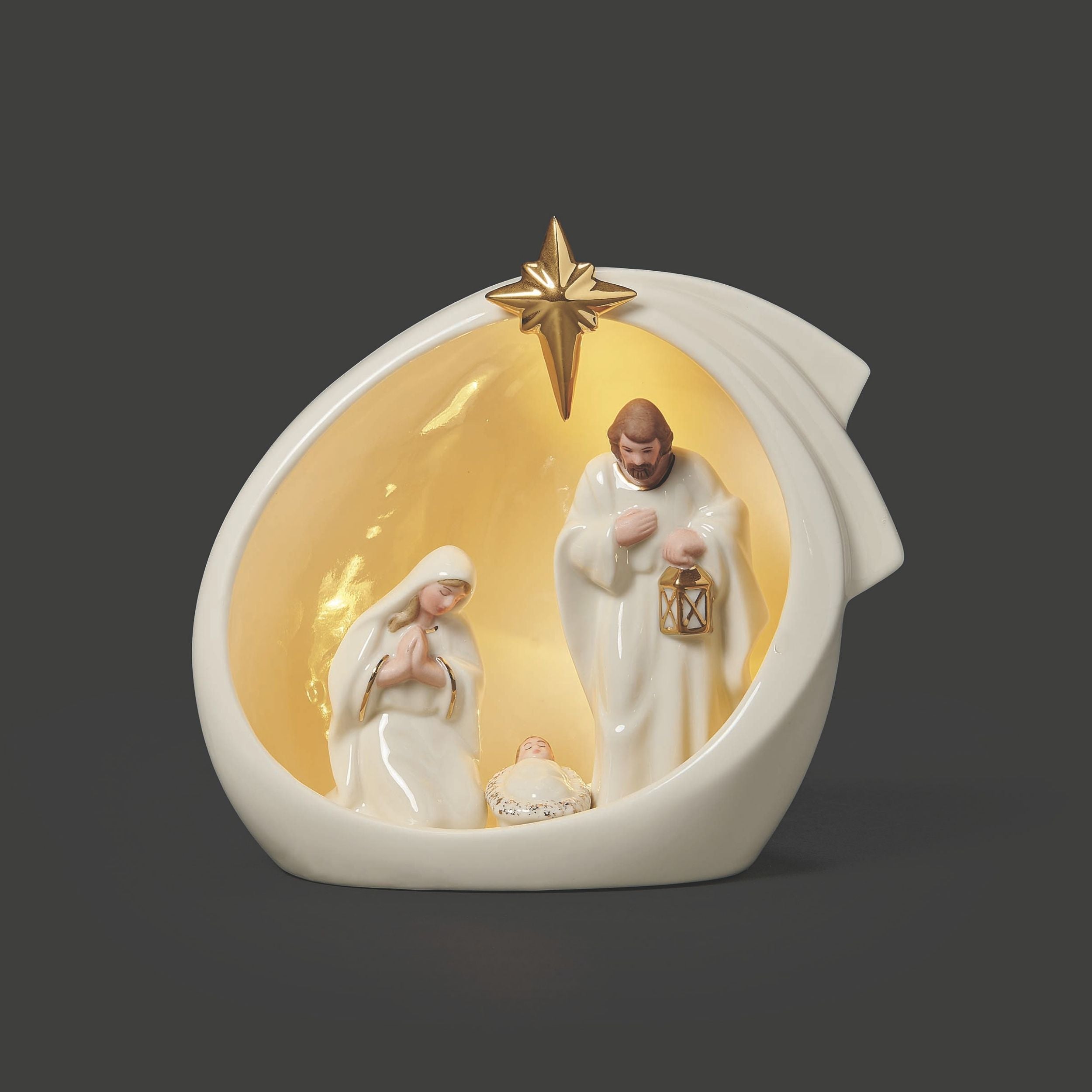 Decorative nativity scene with Mary, Joseph, and baby Jesus in a cave-shaped display case on a dark background.