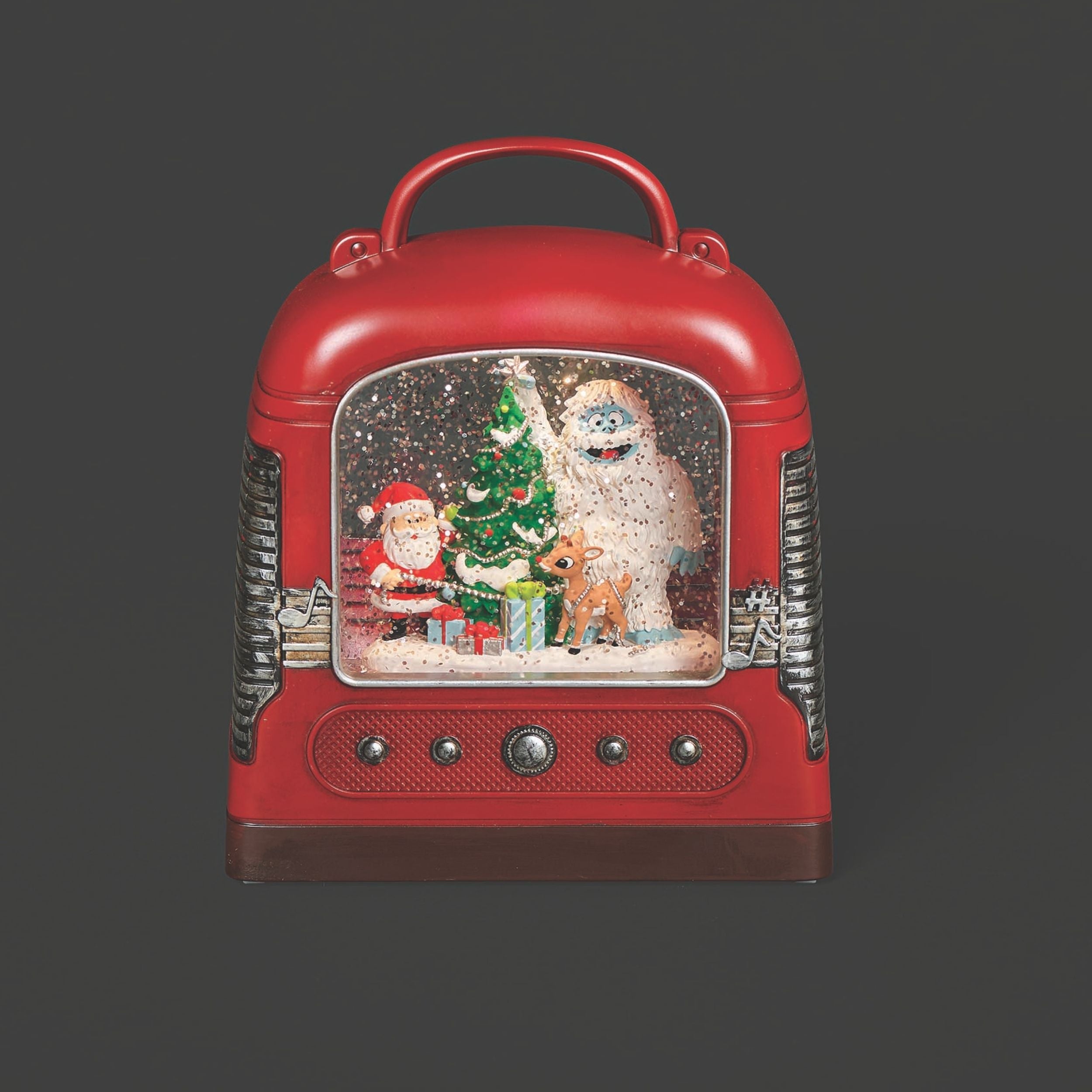 Red vintage-style radio snow globe with Christmas scene on a dark background