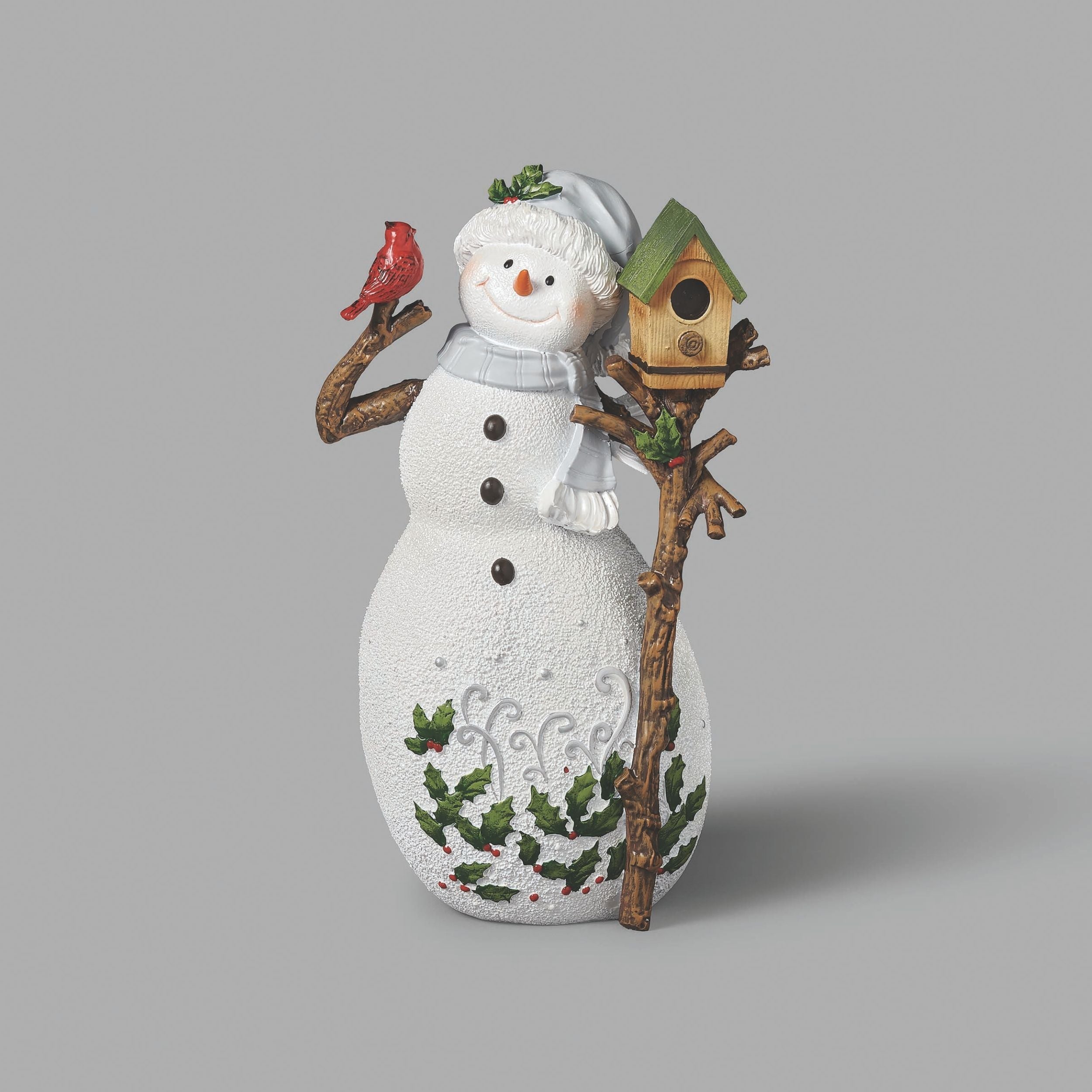 Decorative snowman figurine with a birdhouse and bird on a gray background