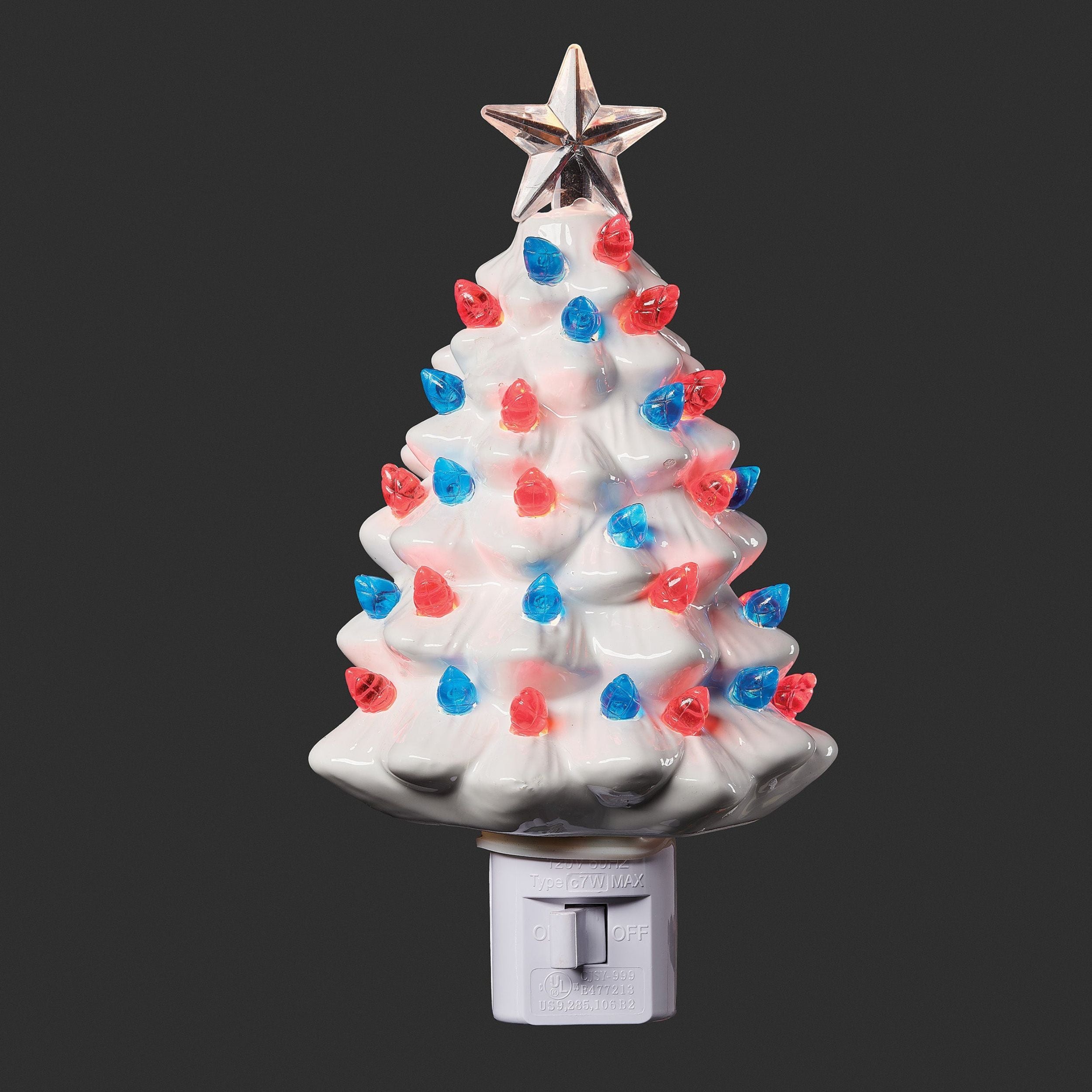 Decorative Christmas tree night light with red, blue, and white lights on a black background