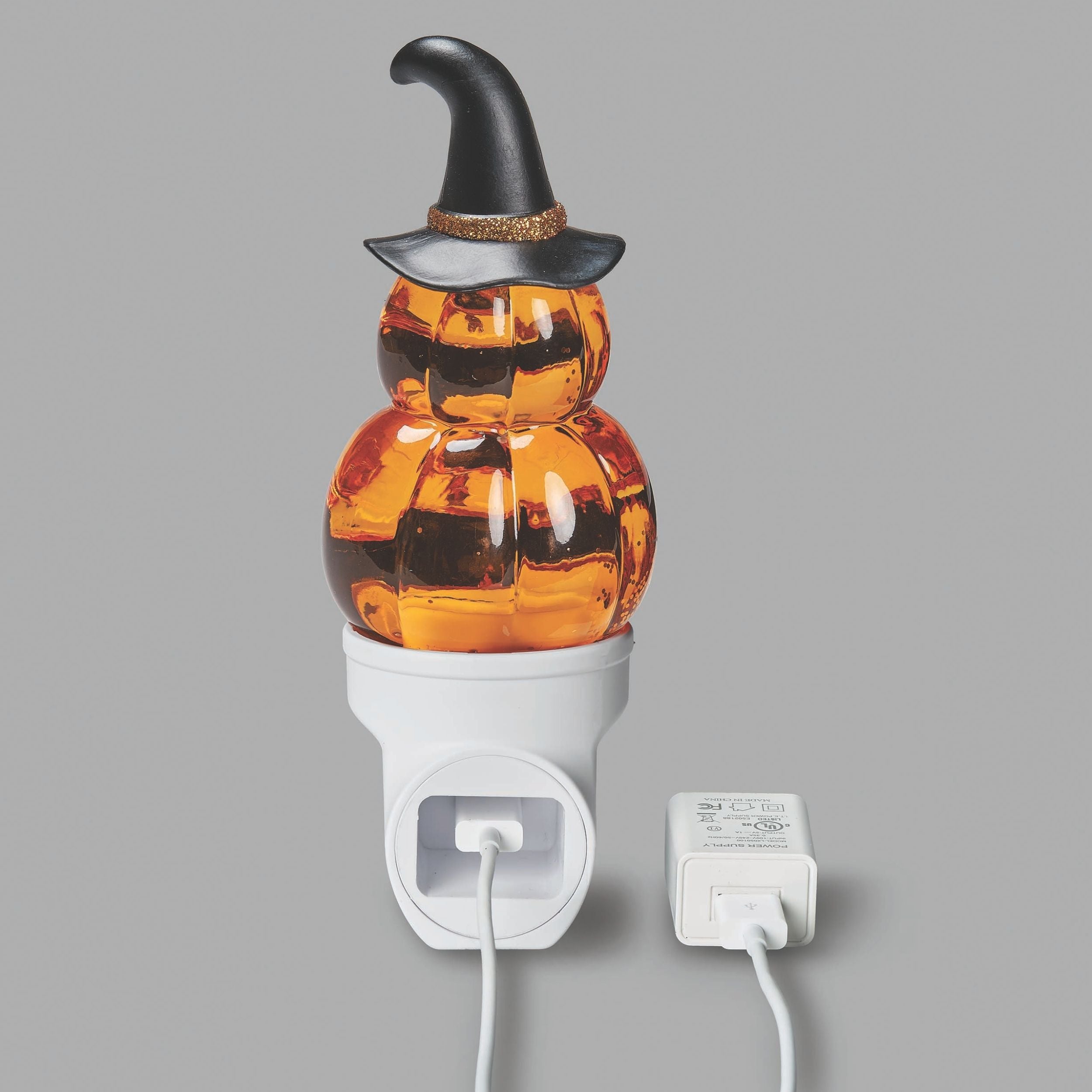 Halloween-themed night light with pumpkin design and witch hat on a gray background