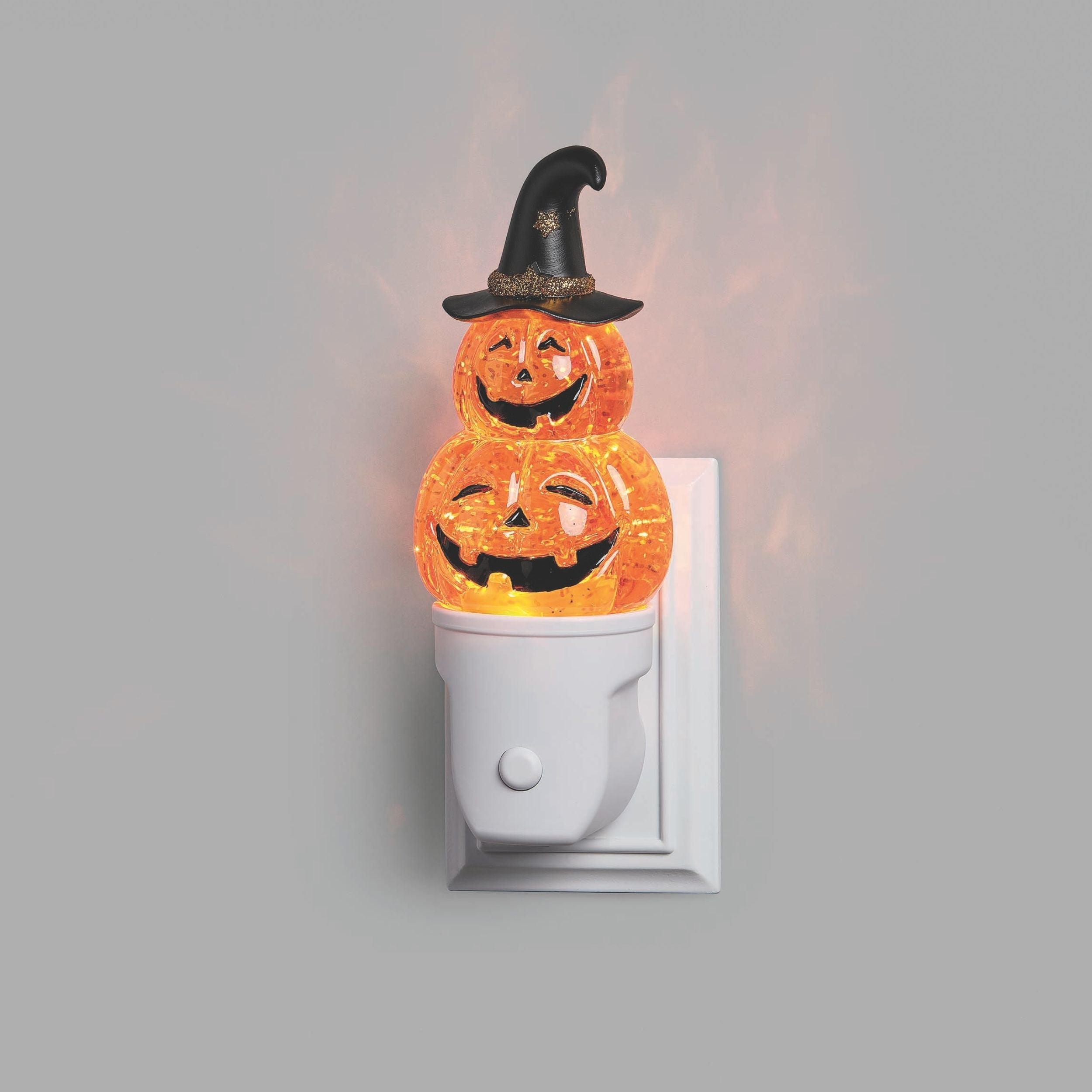 Halloween night light with two jack-o'-lantern faces and a witch hat on a grey background.