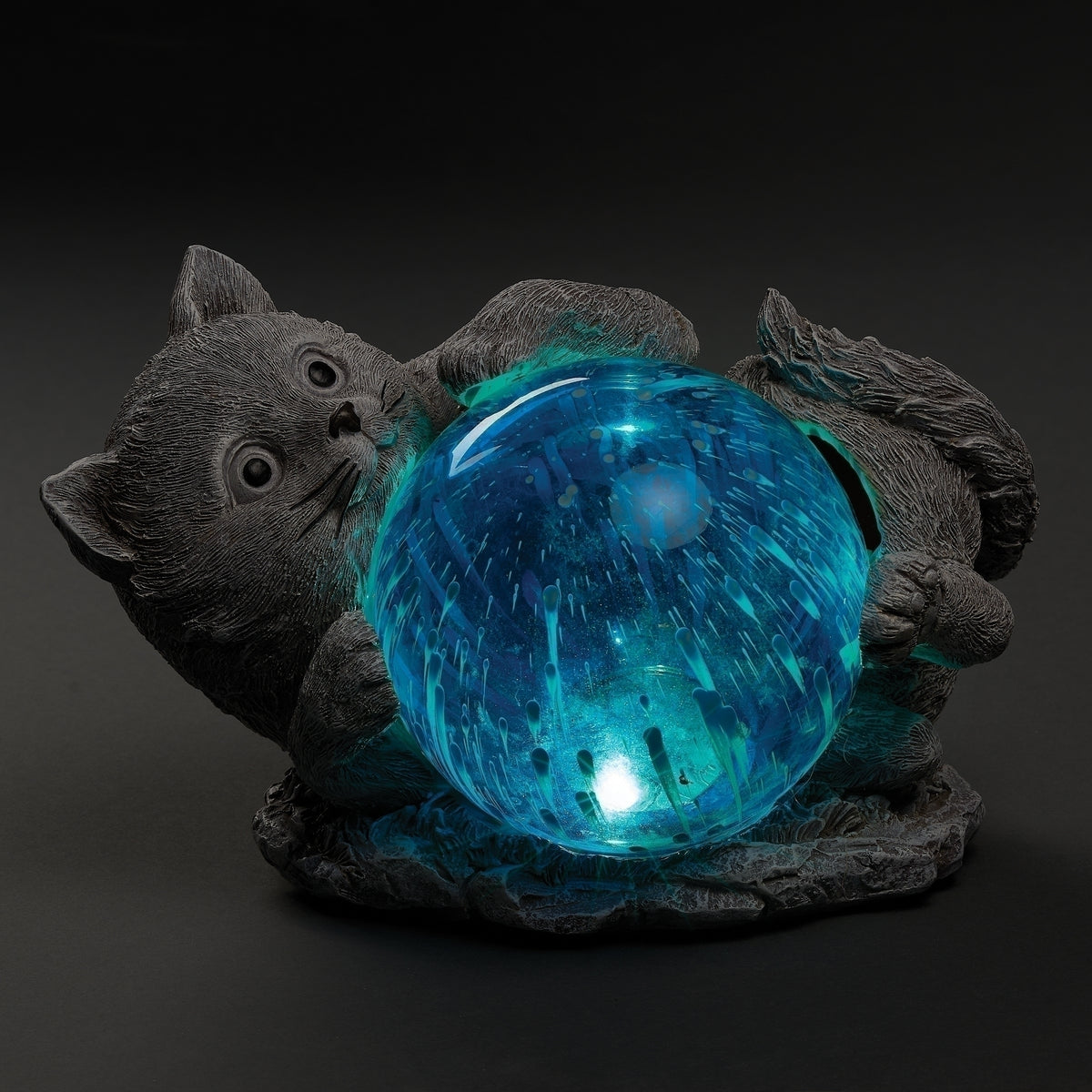 Pudgy Pals Solar-Powered Cat Garden Statue featuring a gray cat curled around a glowing blue orb at night