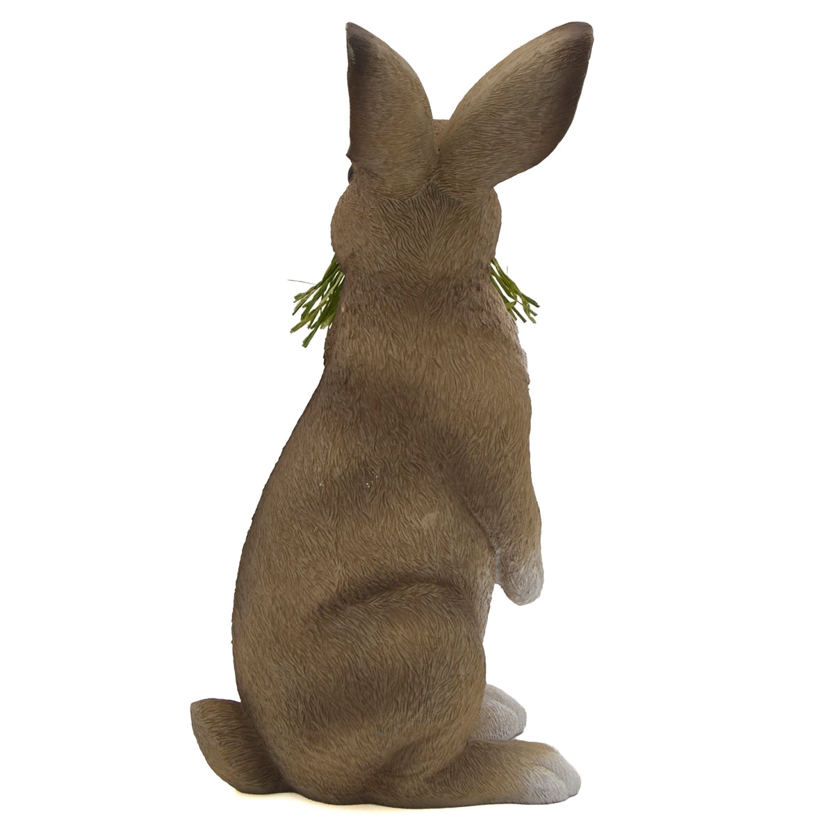 Side view of sitting Easter bunny decoration holding green grass