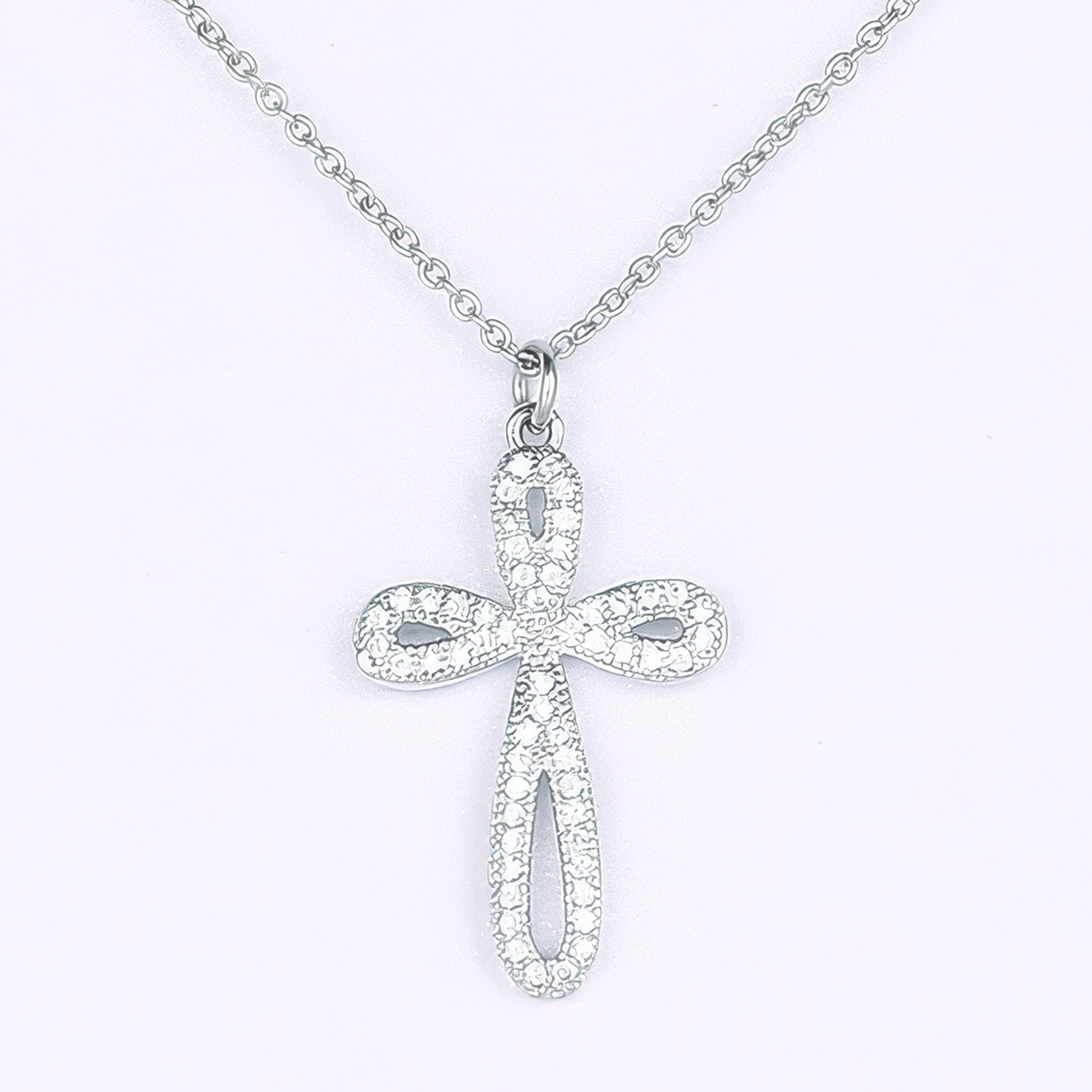 Silver cross pendant necklace on a light gray background