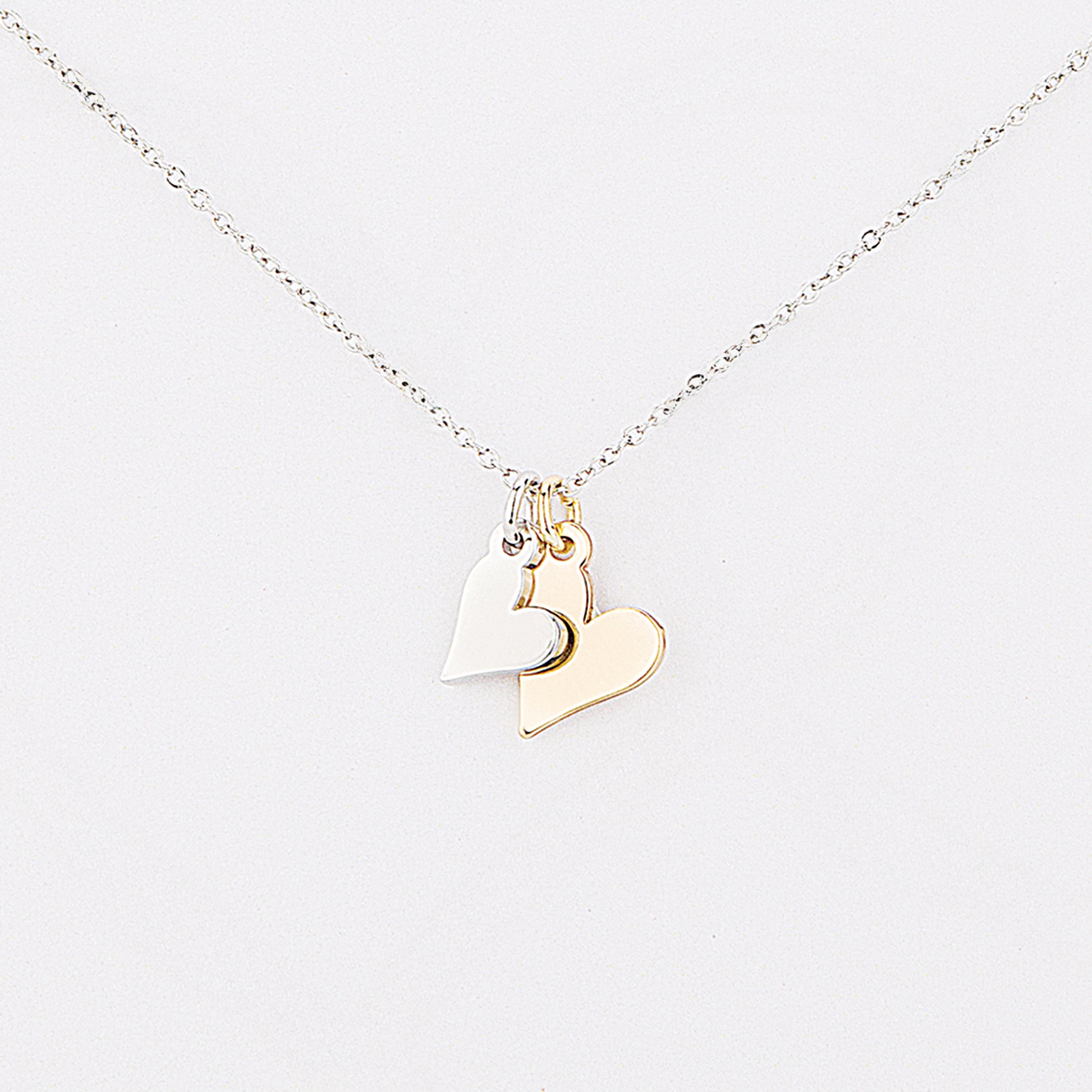 Gold heart-shaped pendant on a silver chain against a white background