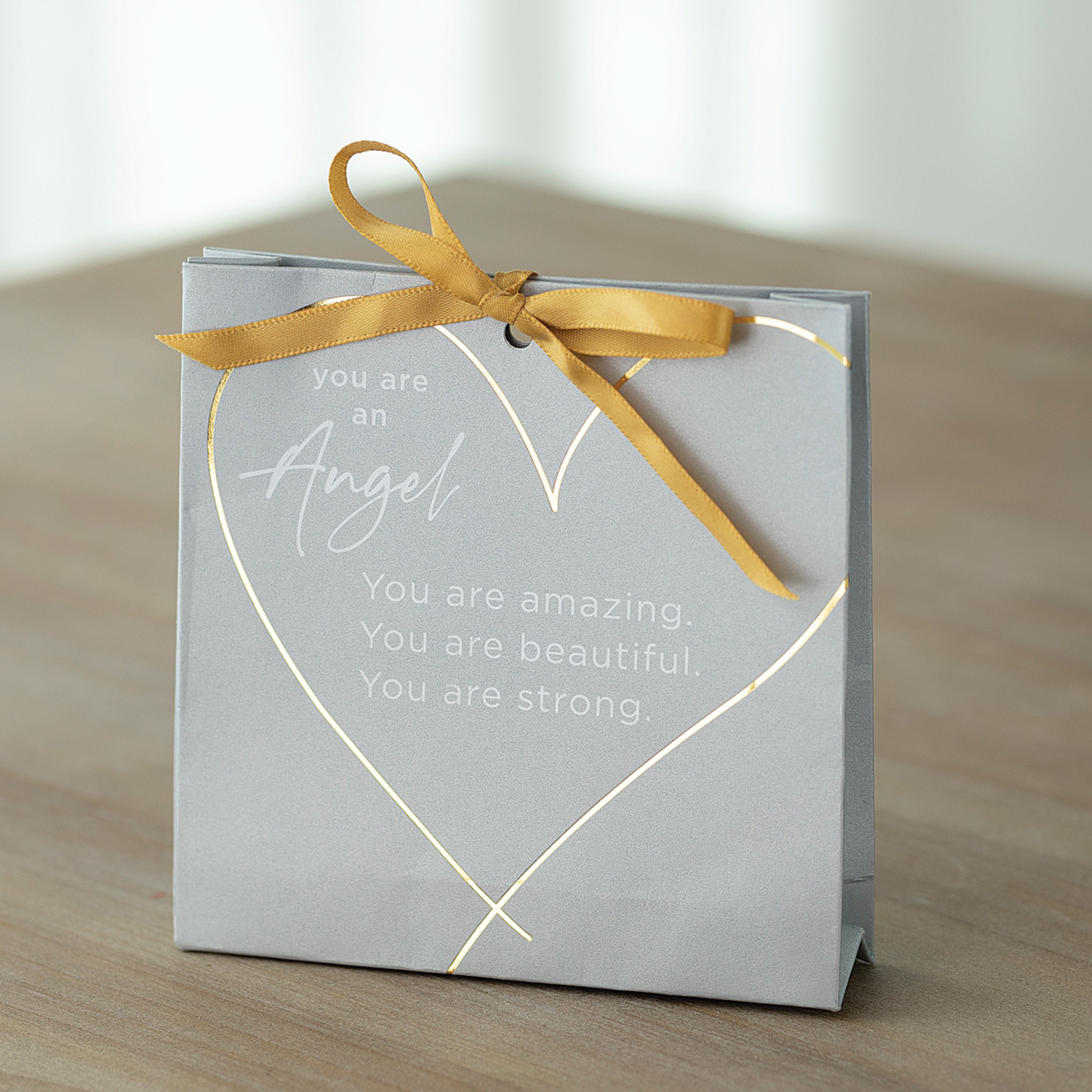 Gray card with gold text and ribbon on a wooden surface