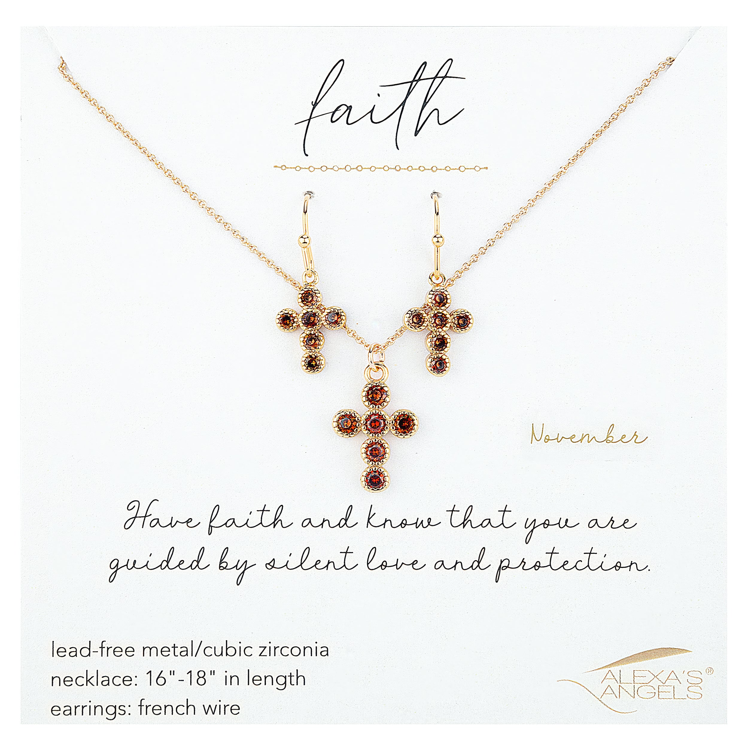 Gold cross necklace and earrings with red gemstones on a white background, featuring the brand 'Alexa's Angels'.