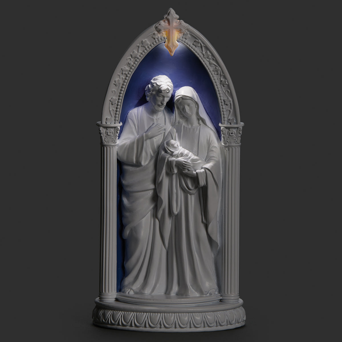 Lighted view of Holy Family in Arch plaque glowing softly around Mary, Joseph, and the Child Jesus