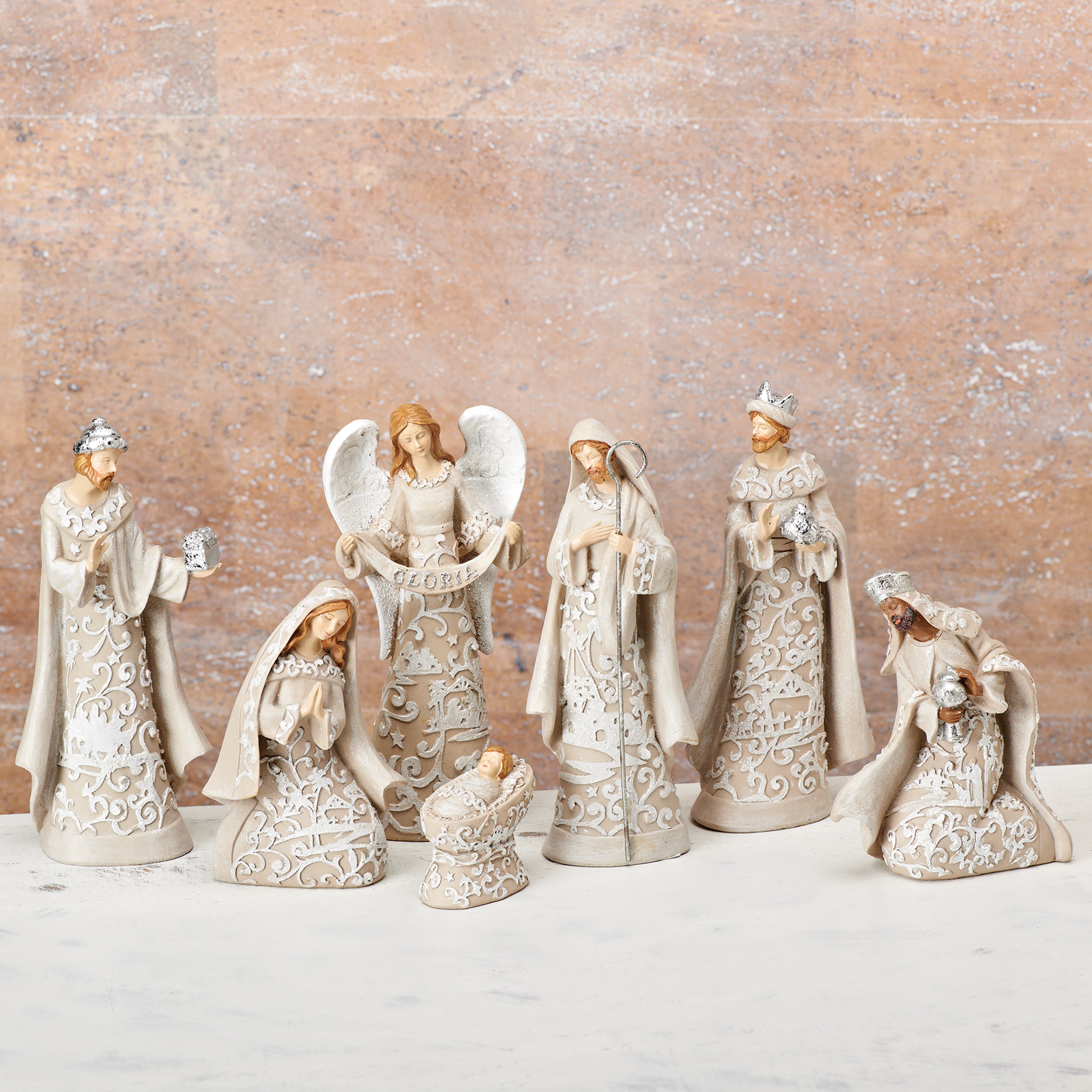 Decorative angel figurines with intricate designs on a textured surface