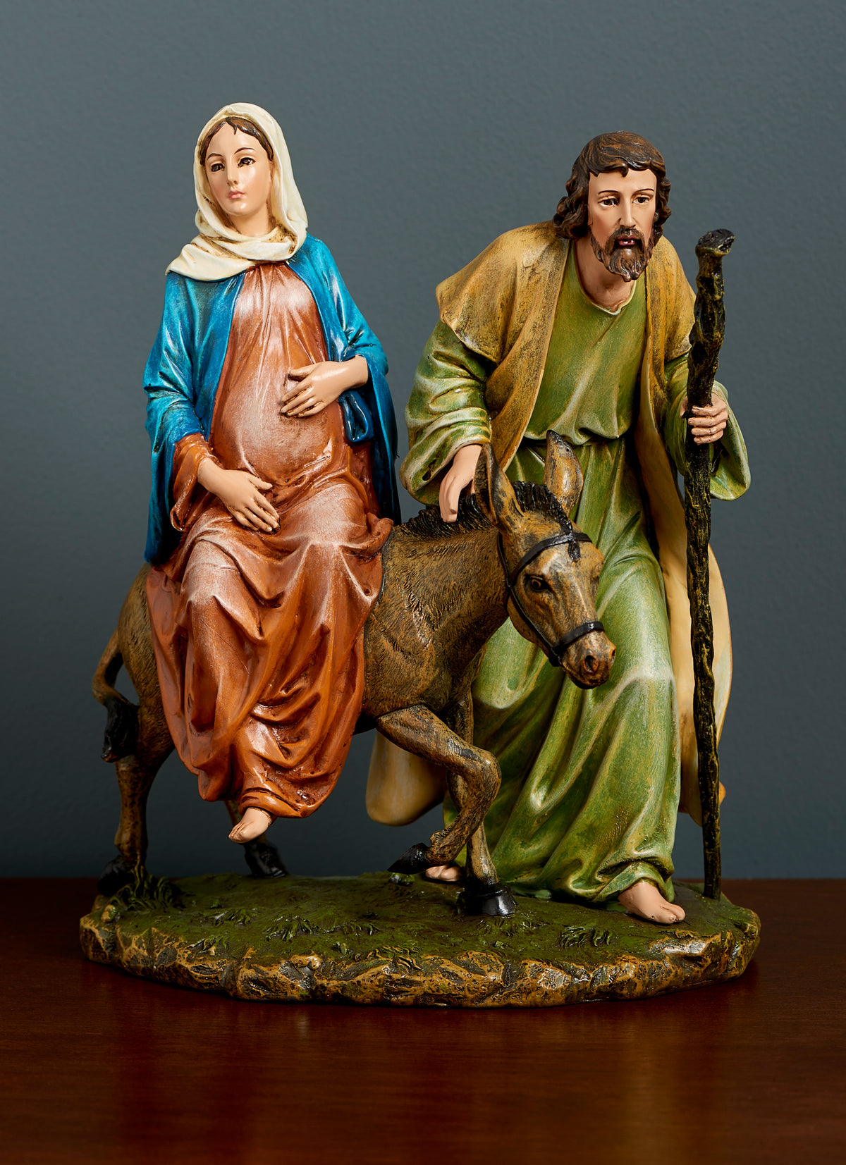 Joseph's Studio La Posada Figure displayed against a dark background featuring Mary on the donkey beside Joseph with his walking staff