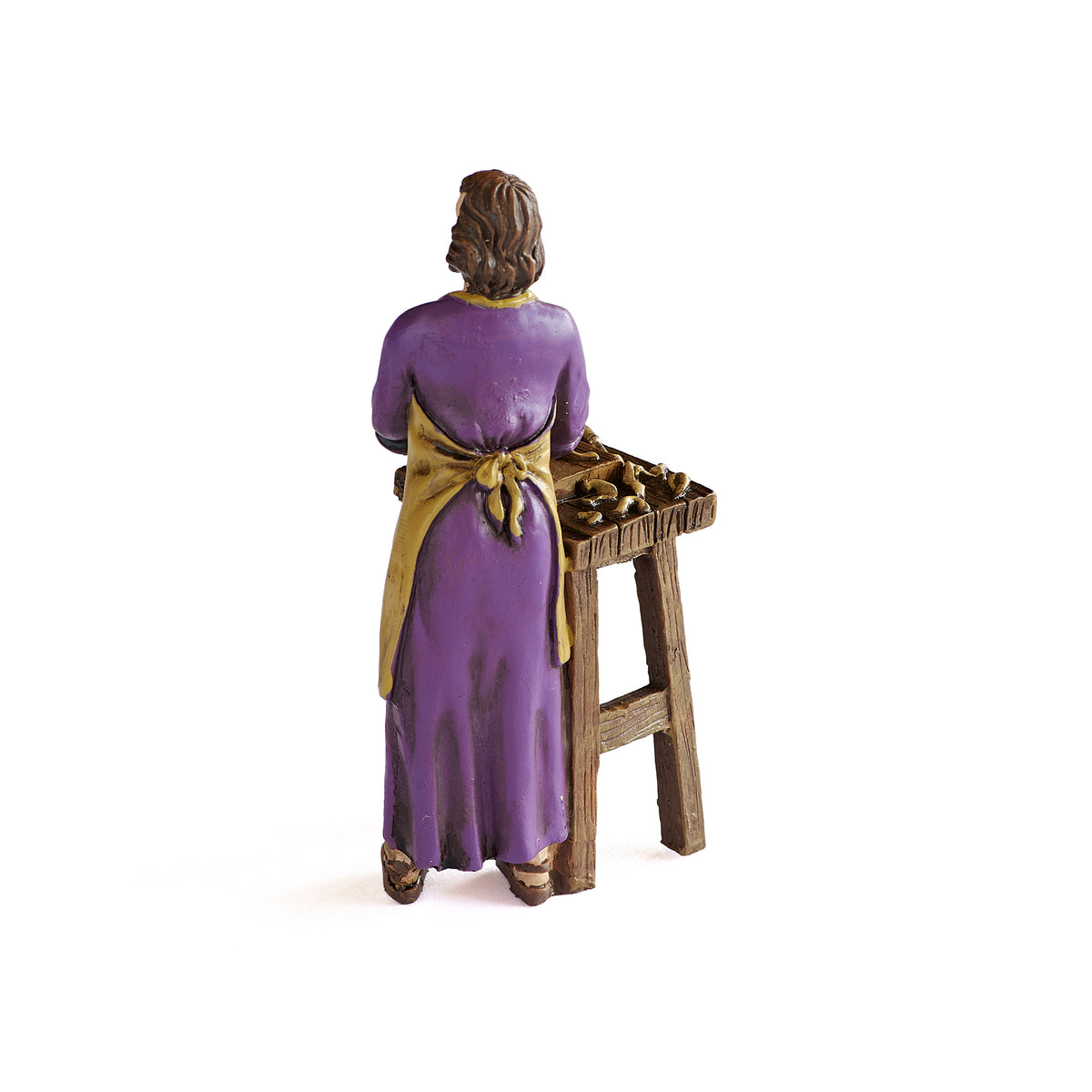 Back view of St. Joseph the Worker figure showing the purple robe and wooden workbench