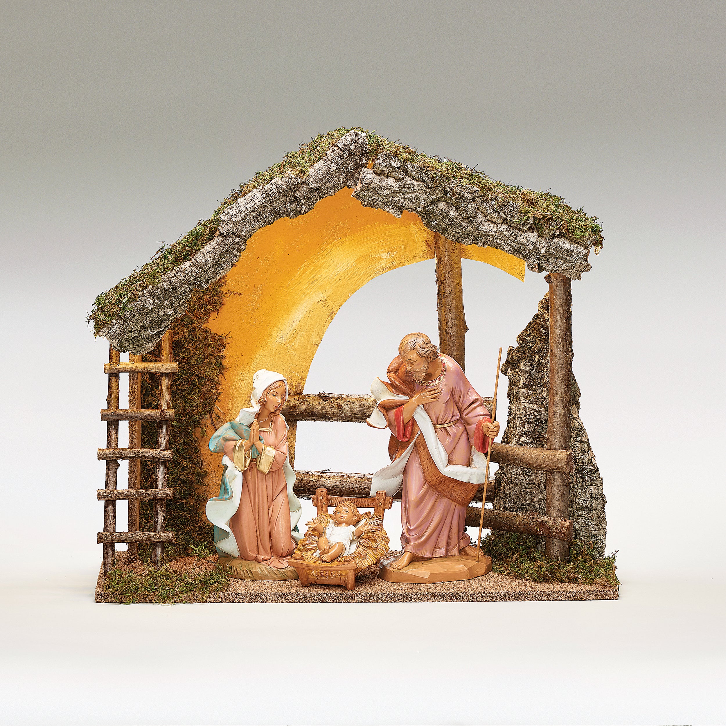 Nativity scene with Mary, Joseph, and baby Jesus in a rustic manger setting.