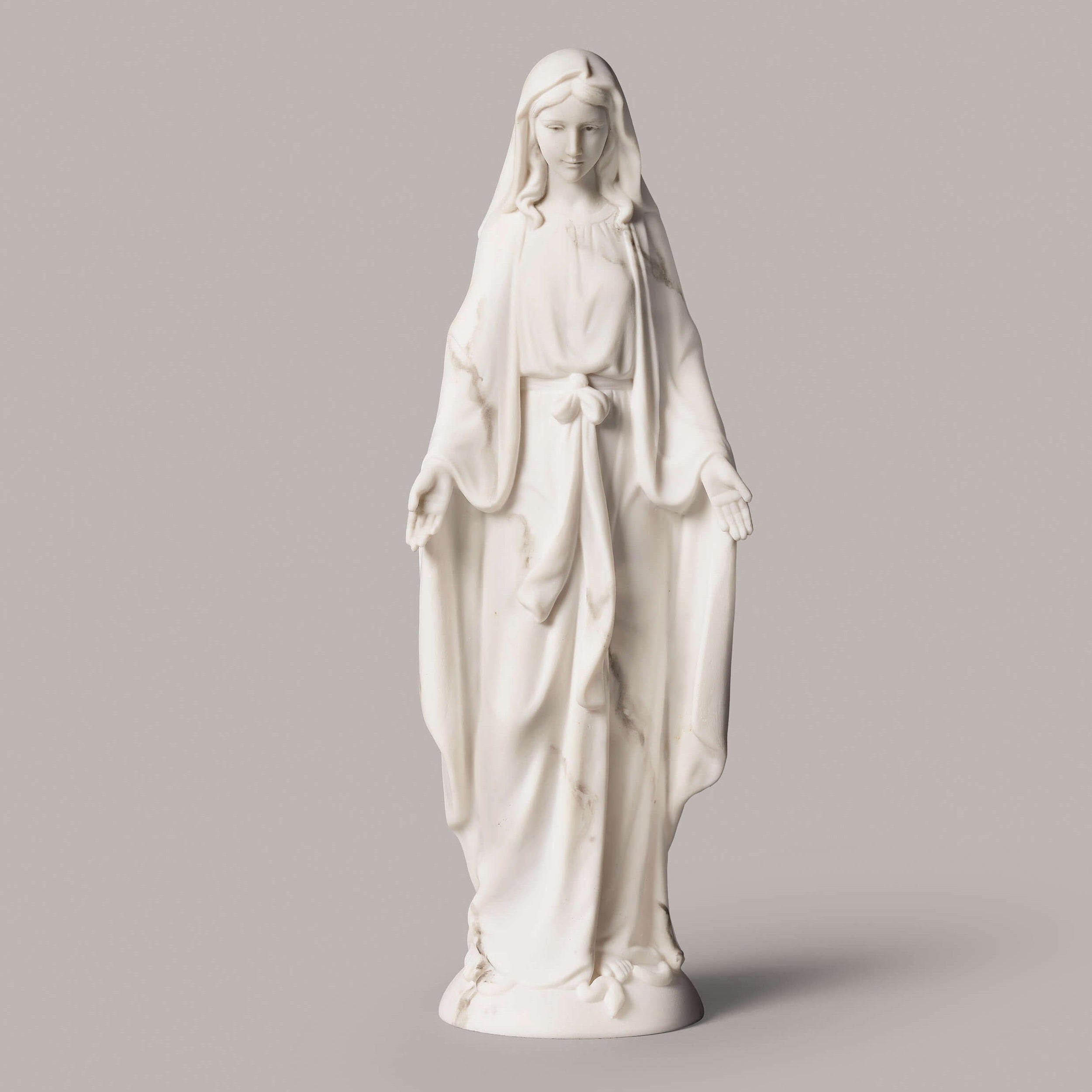White statue of a religious figure on a gray background