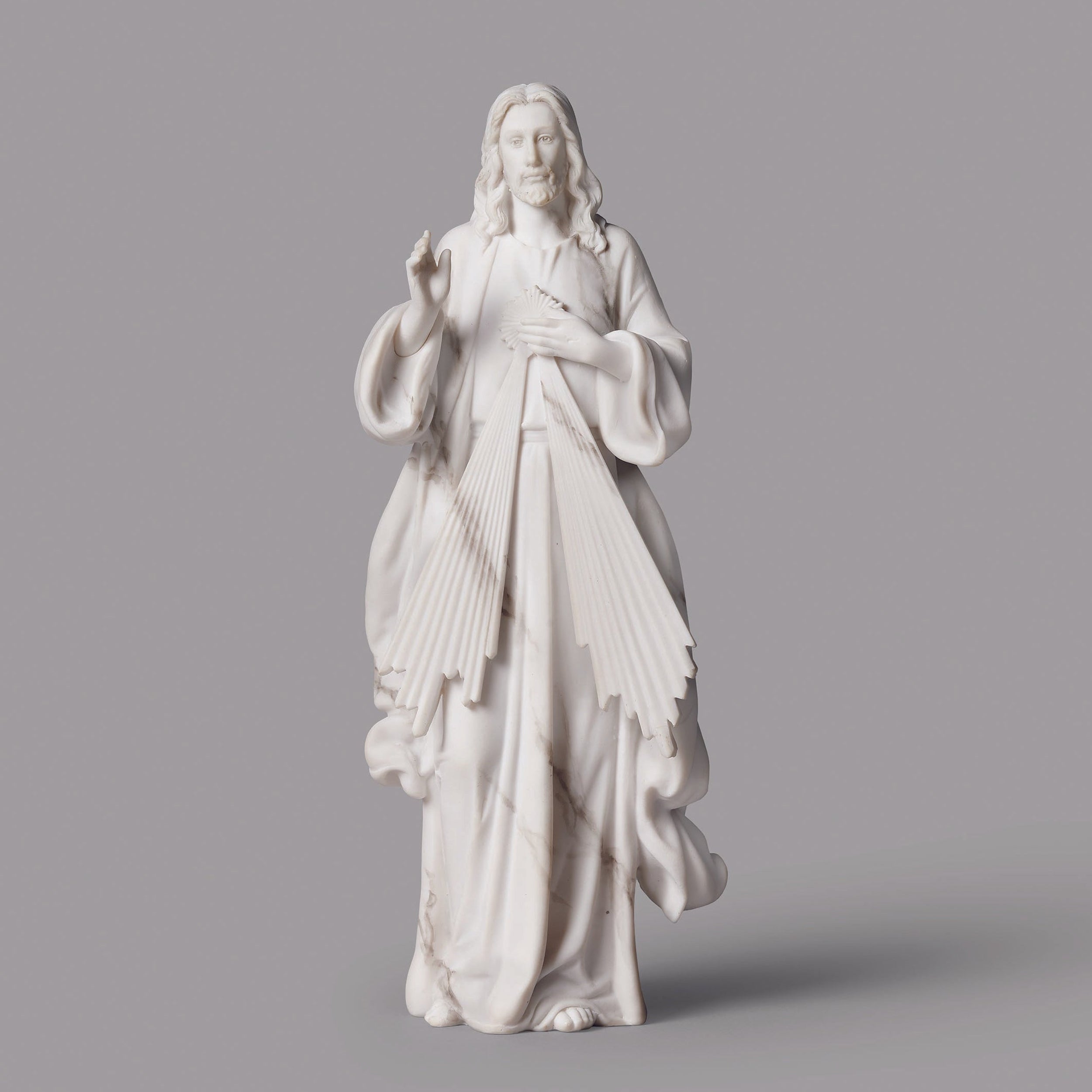 White marble statue of a religious figure on a gray background