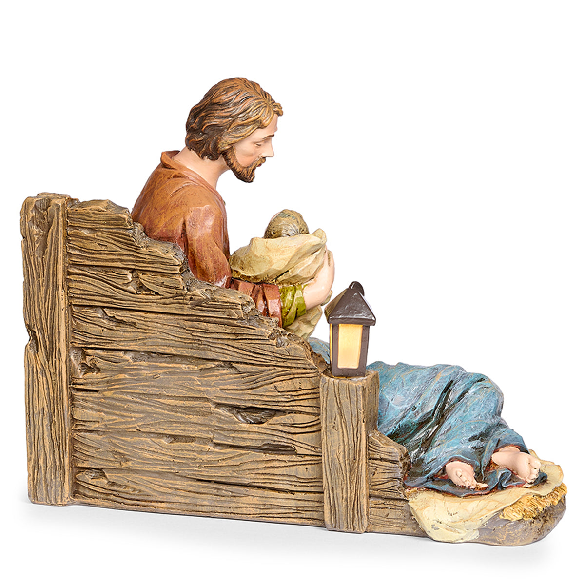 Side view of Joseph's Studio Lighted Sleeping Mary Holy Family Figure showing Joseph cradling baby Jesus while Mary rests beside the rustic wood-look structure