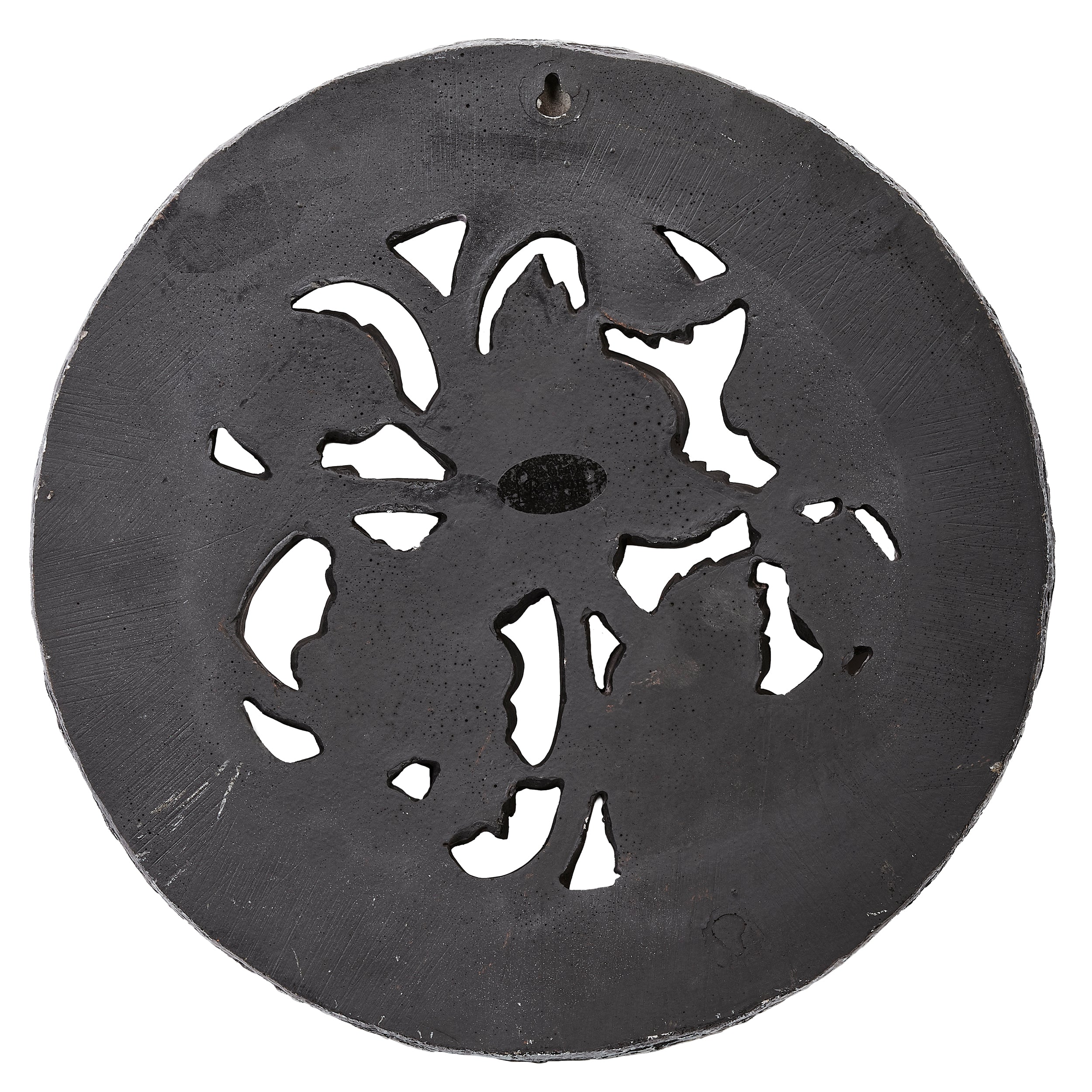 Decorative metal disc with cut-out floral design on a white background
