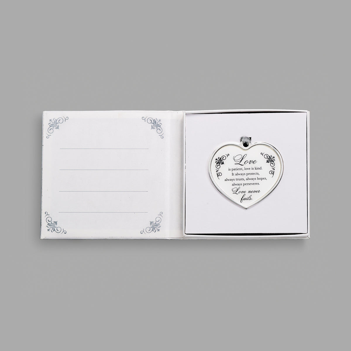 Open keepsake packaging displaying the Love Is Patient heart ornament beside a printed message.