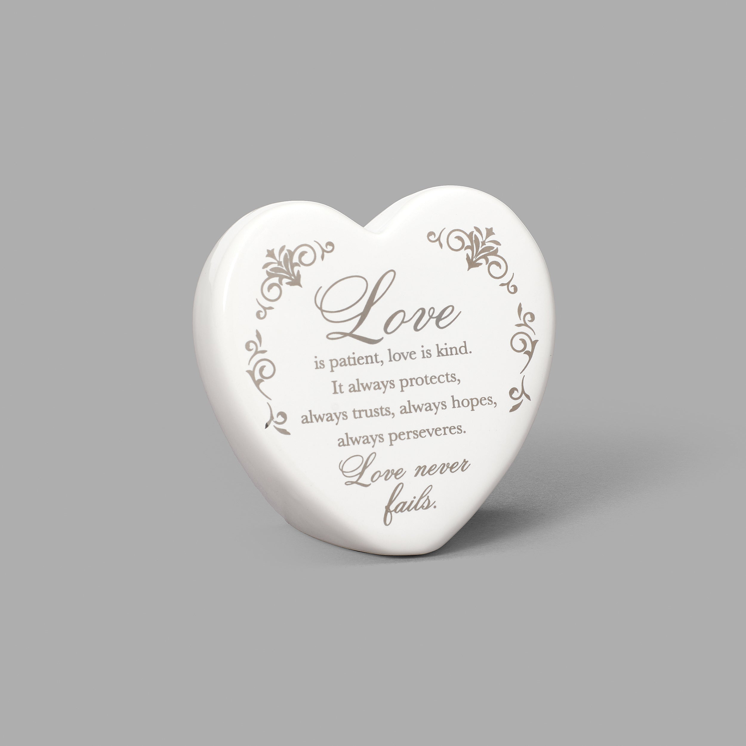 Heart-shaped object with engraved text on a gray background