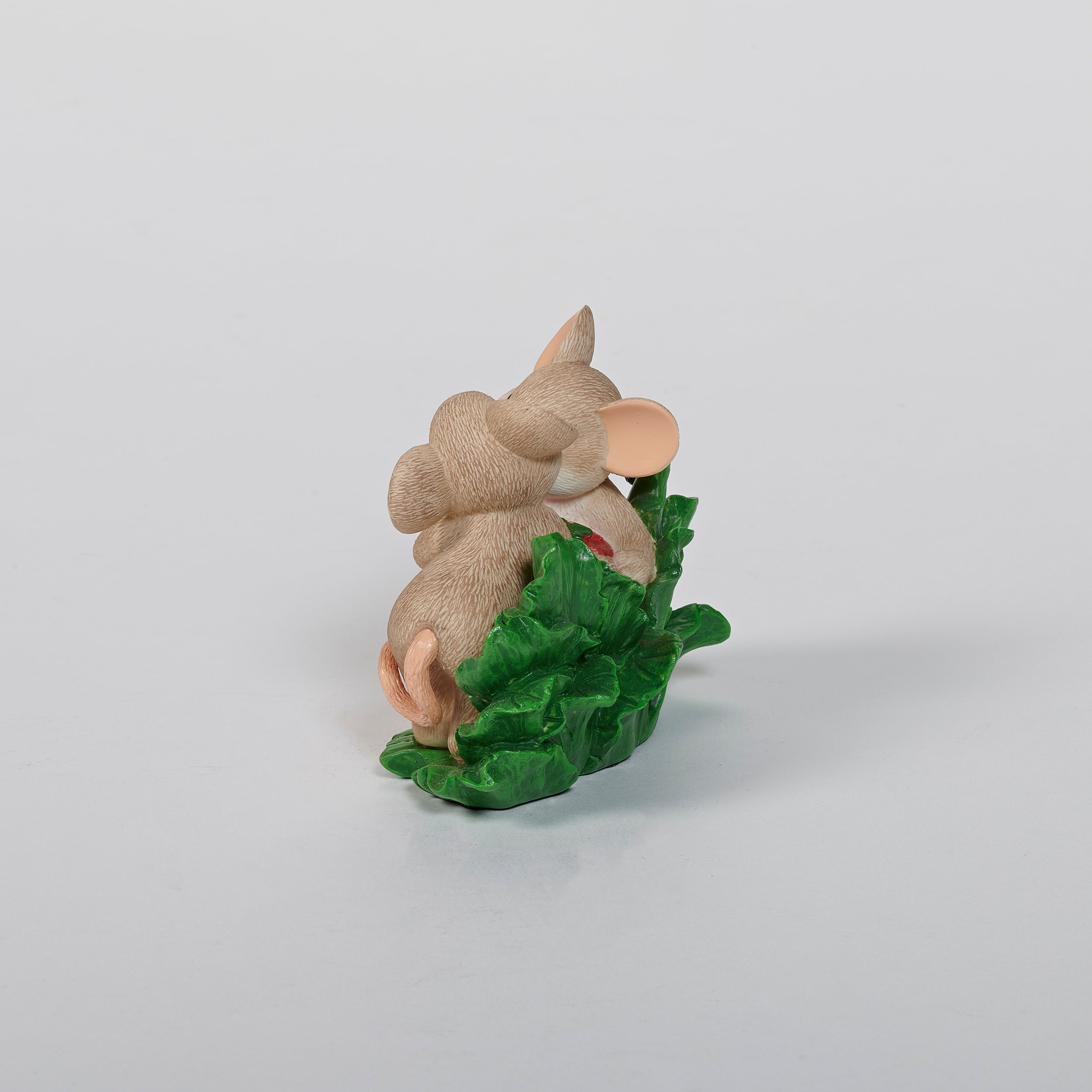 Two mouse figurines holding a strawberry