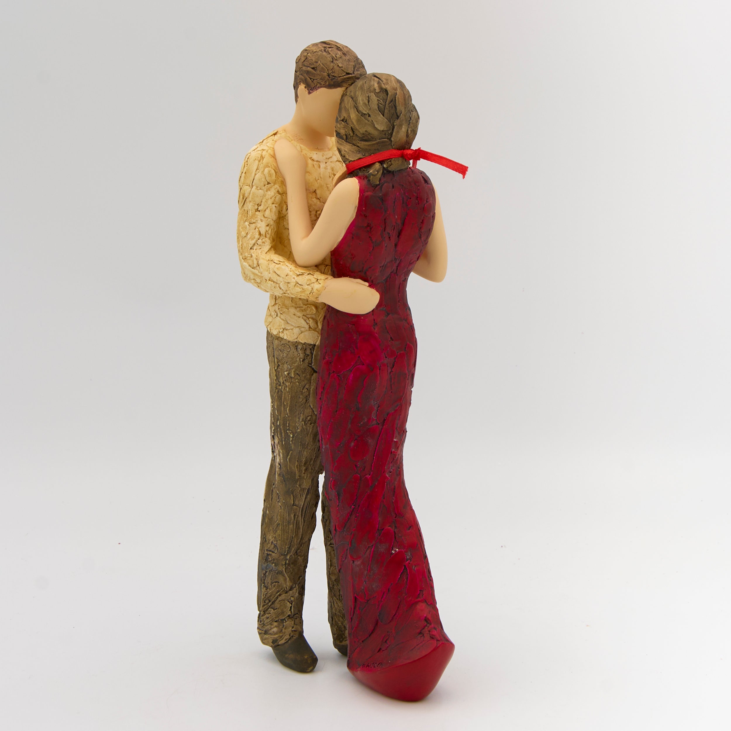 Statue of a couple embracing, one in a red dress and the other in a yellow sweater