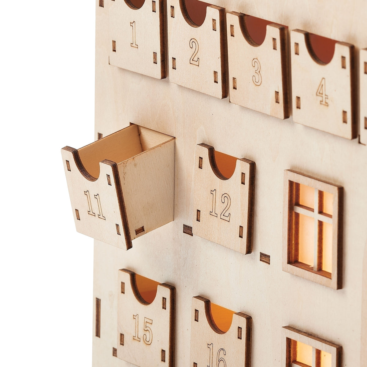 Close-up of the wooden Advent calendar showing a numbered drawer pulled open beside the decorative windows.