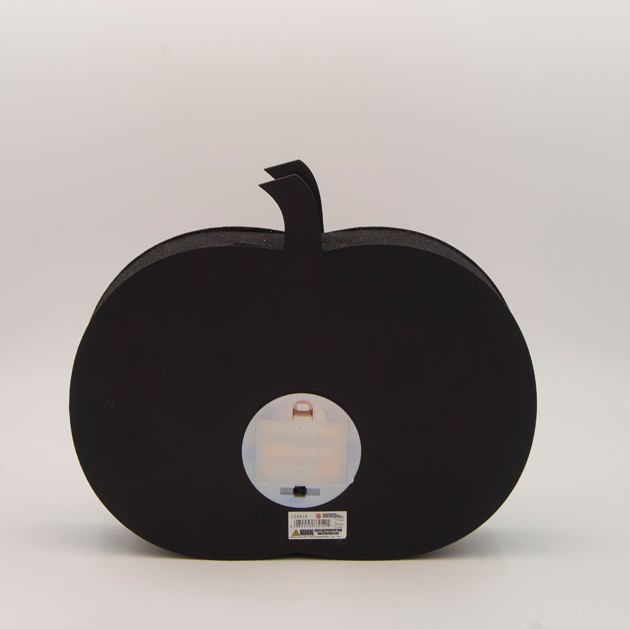 Halloween-themed pumpkin decoration showing the back with a battery opening