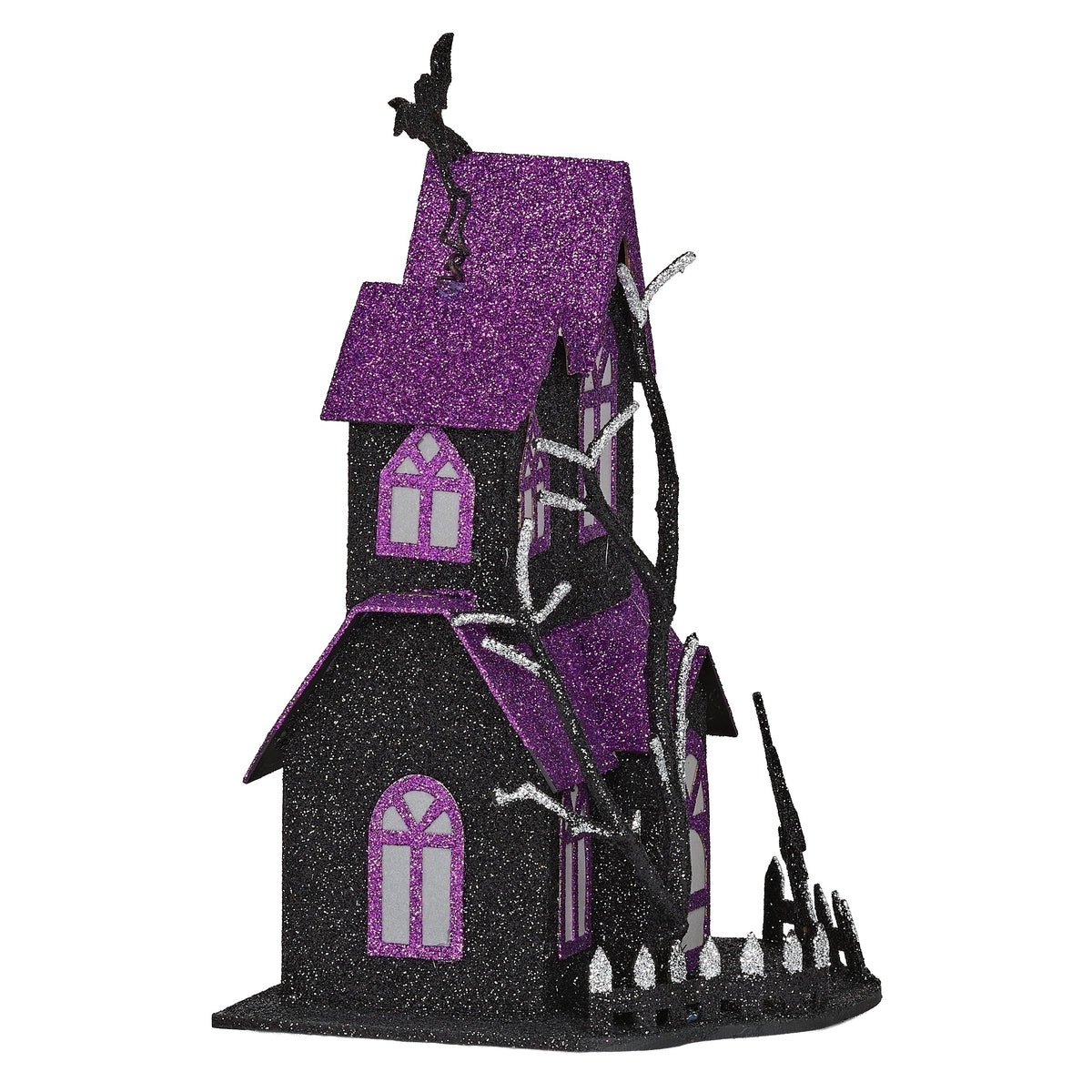 Opposite angled view of haunted house showing its tall tower, purple roofs, bare branches, and fence.