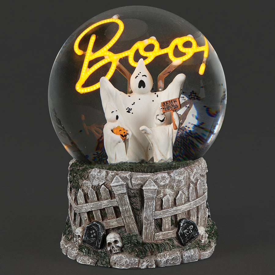 Illuminated Halloween snow globe with white ghosts beneath a glowing yellow “Boo” sign and a graveyard base decorated with fences and skulls.