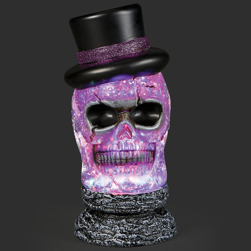 Decorative skull with a black top hat and purple glittery finish on a dark background