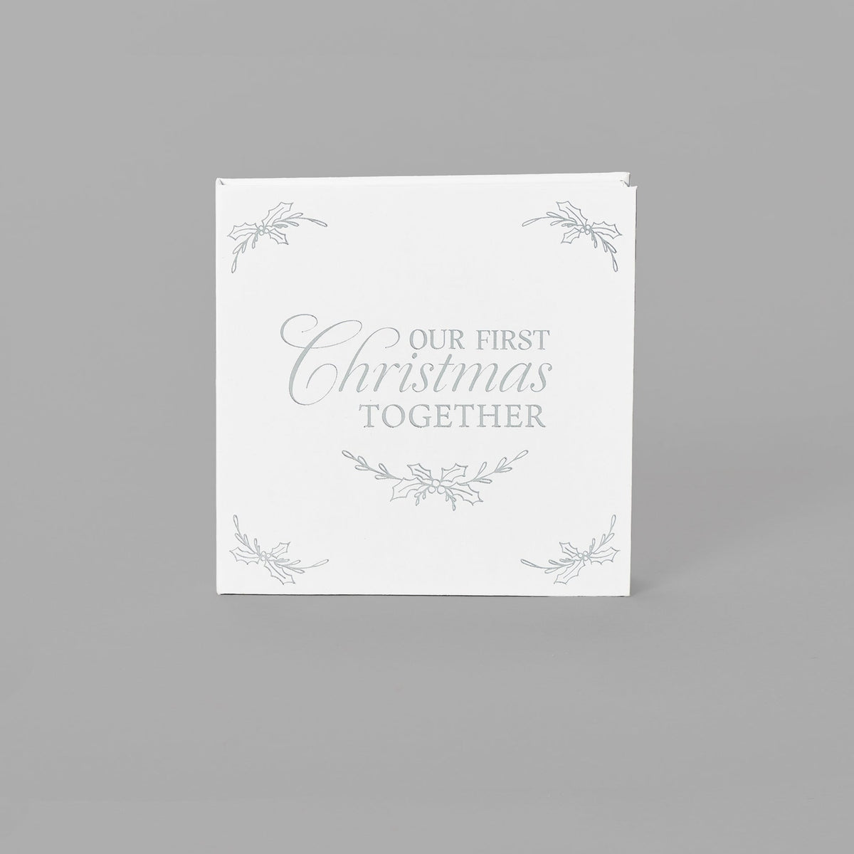 Closed white keepsake packaging with a decorative wreath design and delicate corner accents.