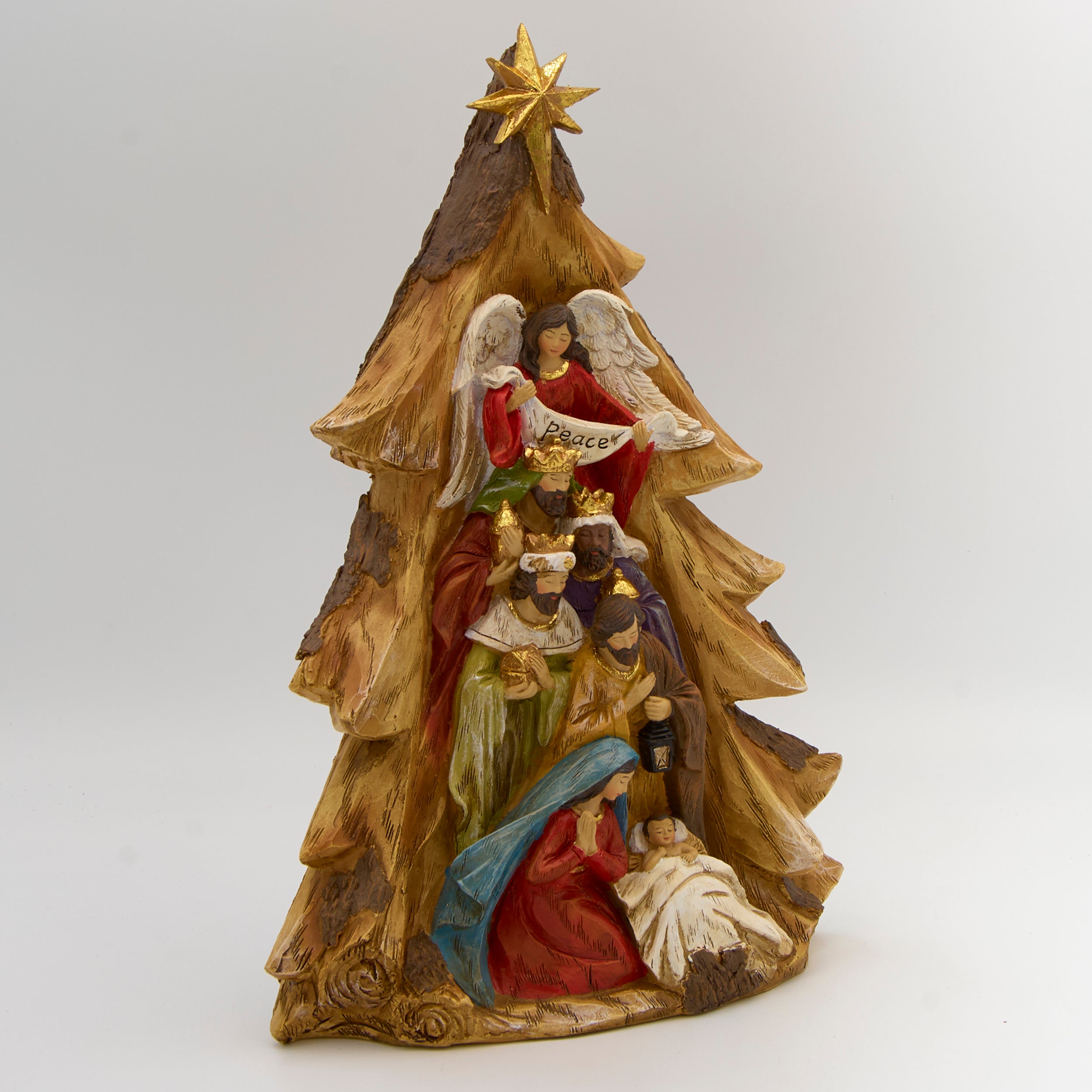 Decorative nativity scene figurine with angel holding 'Peace' on a white background