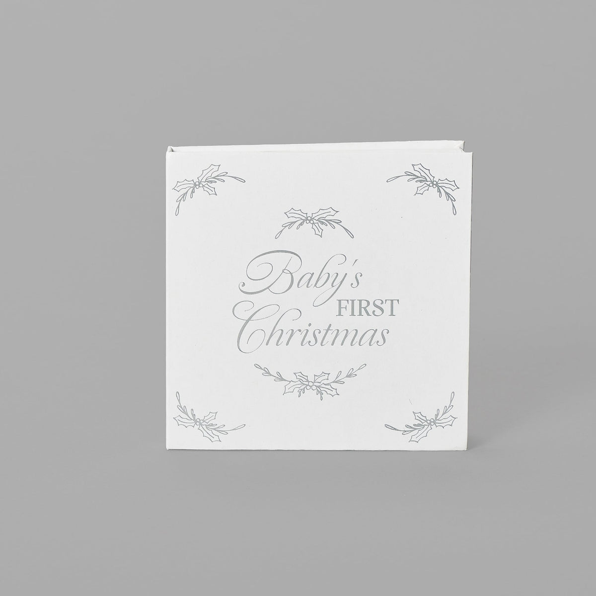 Closed white keepsake packaging with a decorative wreath design and delicate corner accents.