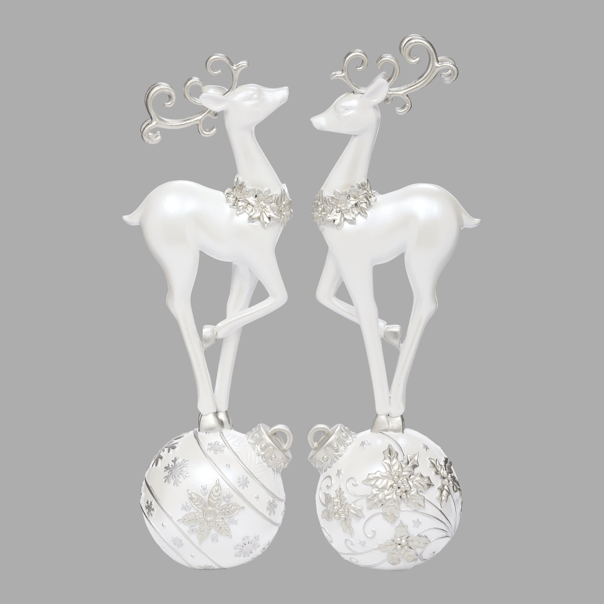 Pair of white deer figurines with decorative elements on a gray background