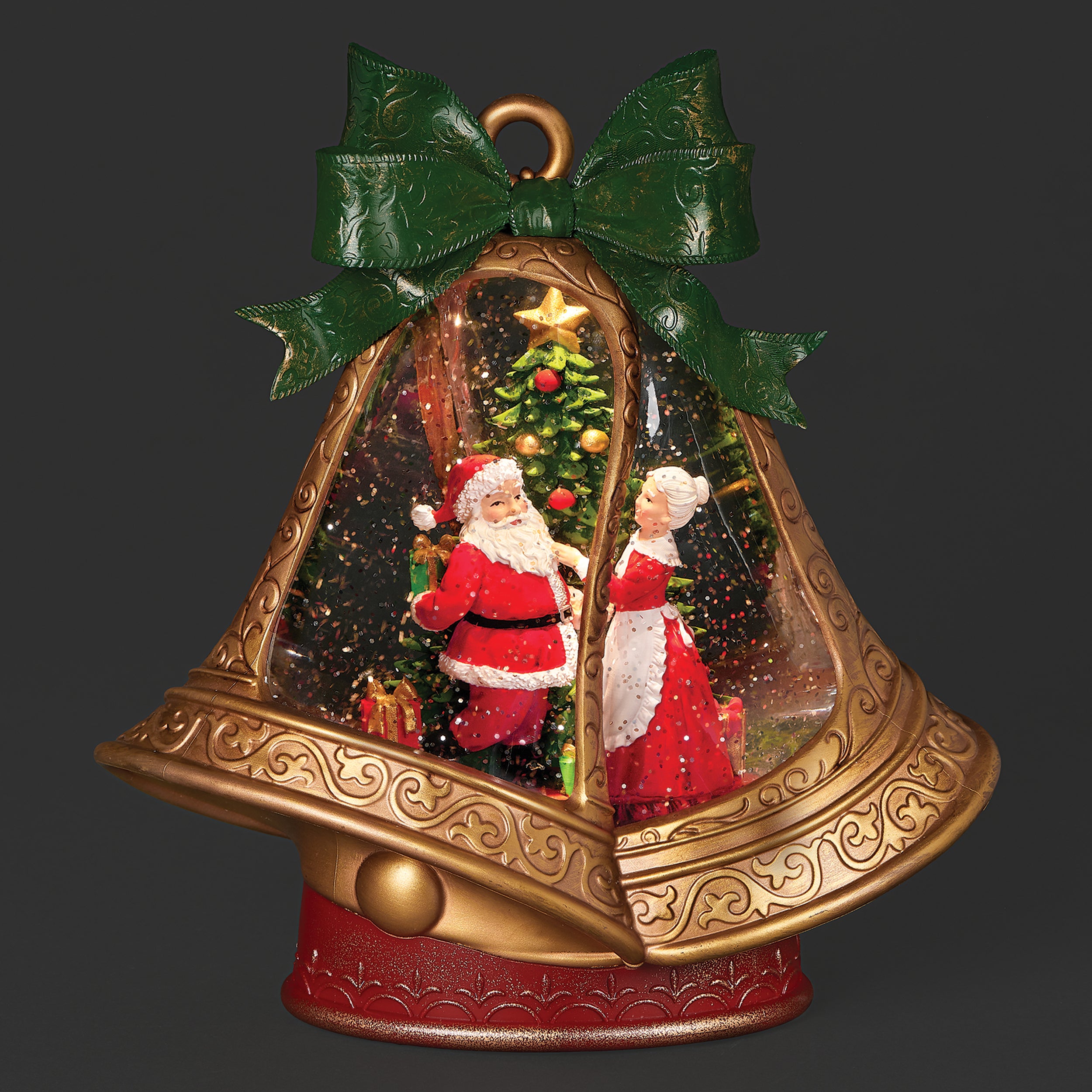 Decorative Christmas bell with Santa Claus and Mrs. Claus inside, on a dark background