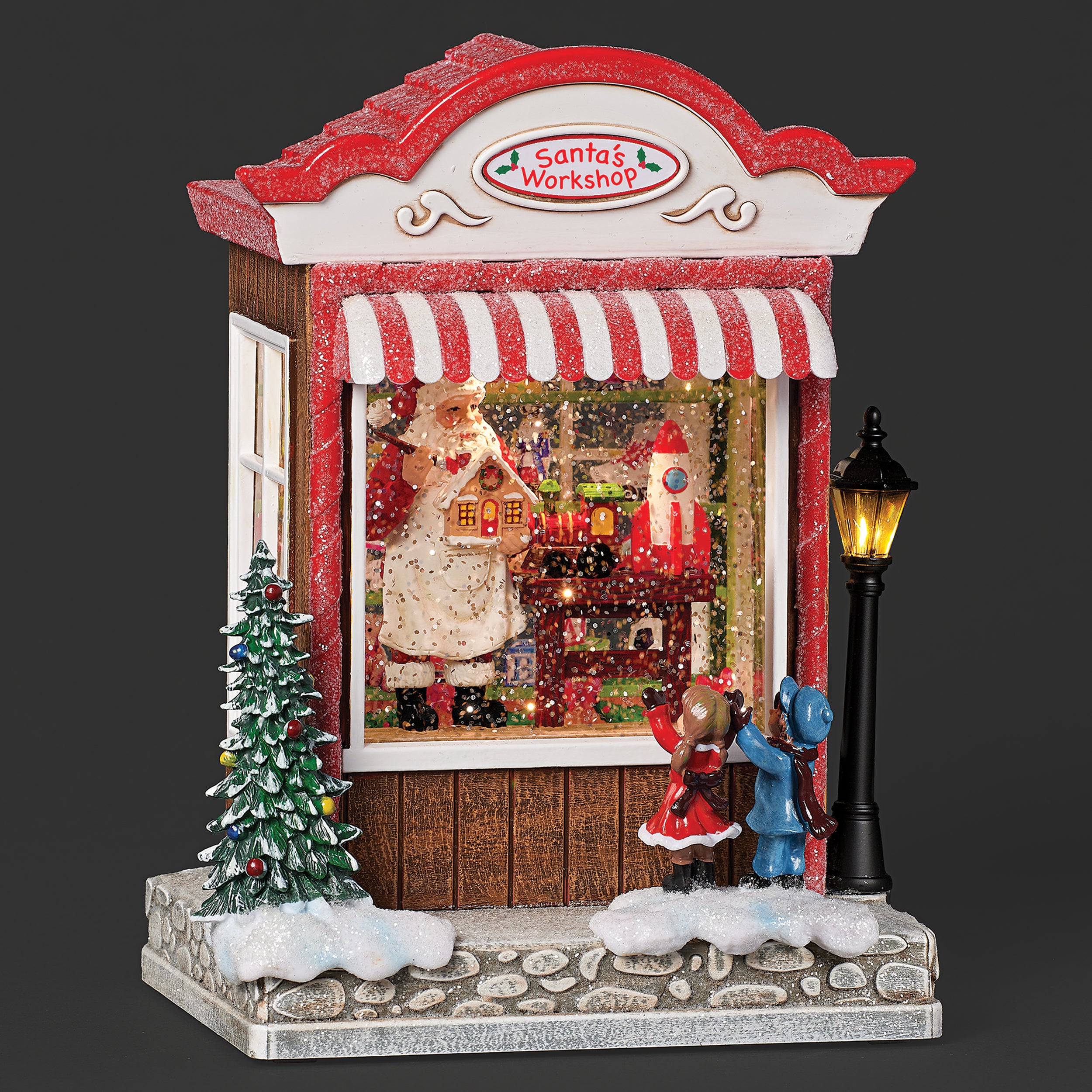 Decorative Christmas scene with Santa's Workshop, Christmas tree, and characters on a dark background.
