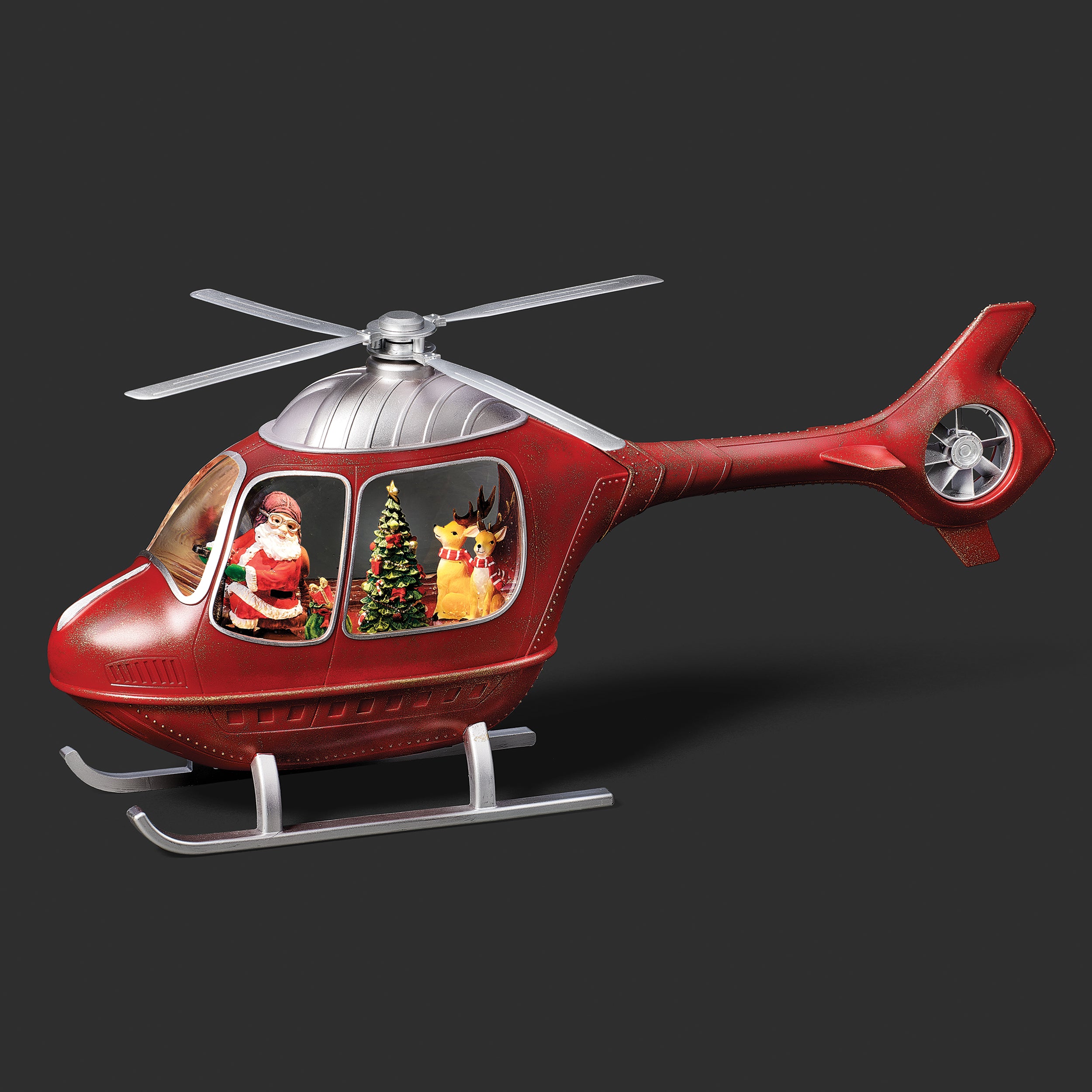Red helicopter toy with Santa Claus and reindeer inside on a dark background
