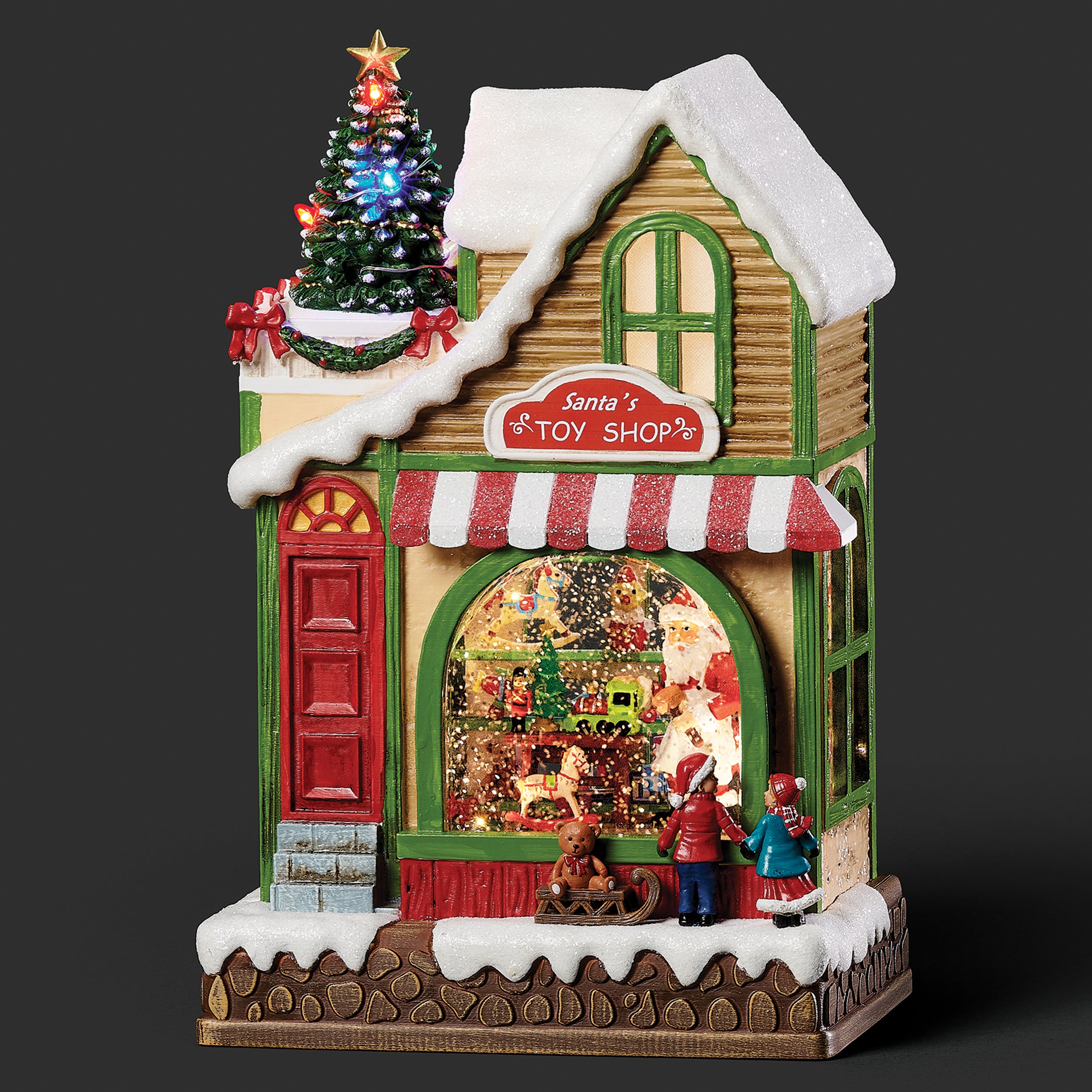 Decorative Christmas toy shop with animated figures and a lit-up tree on a dark background