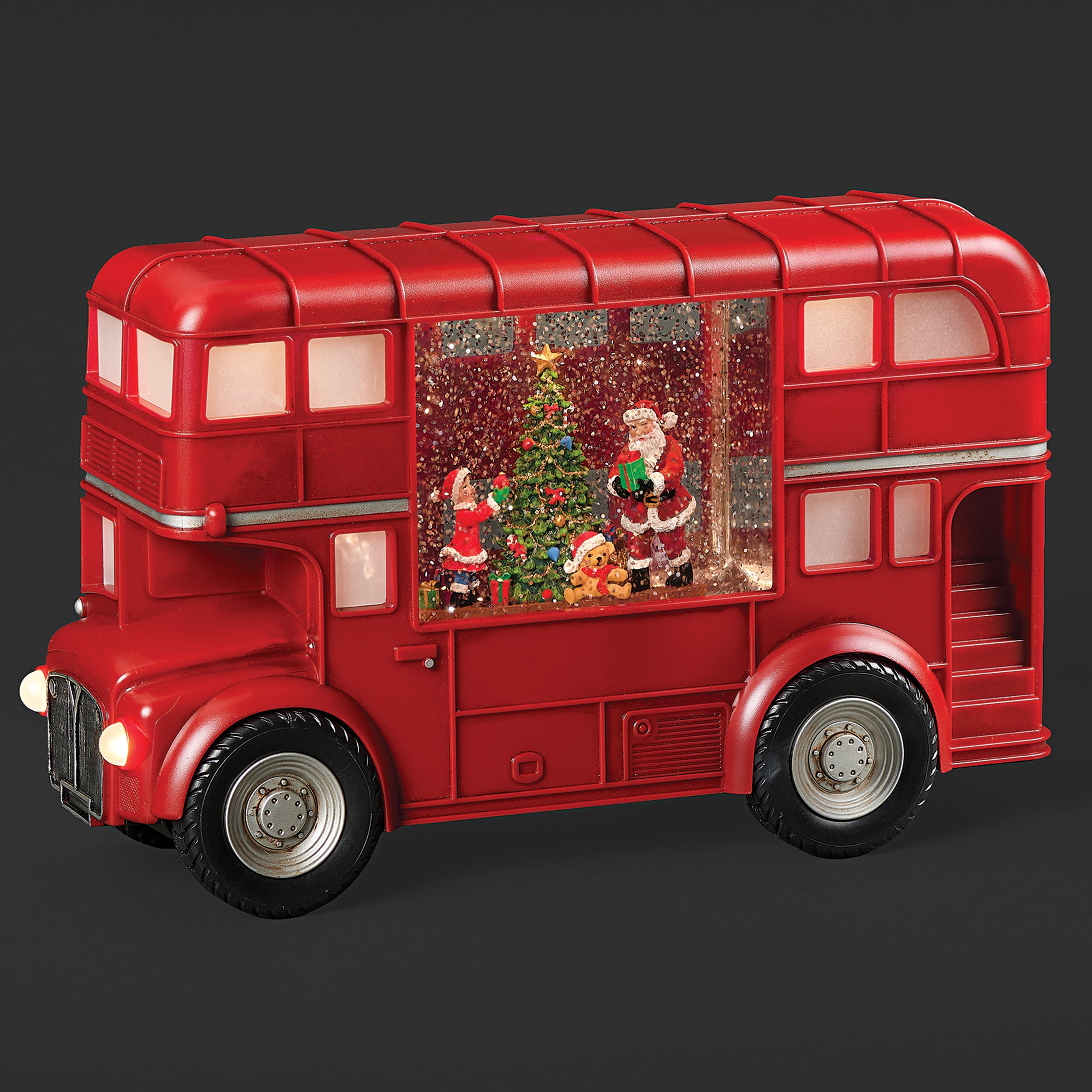Red double-decker bus with Christmas scene inside on a dark background