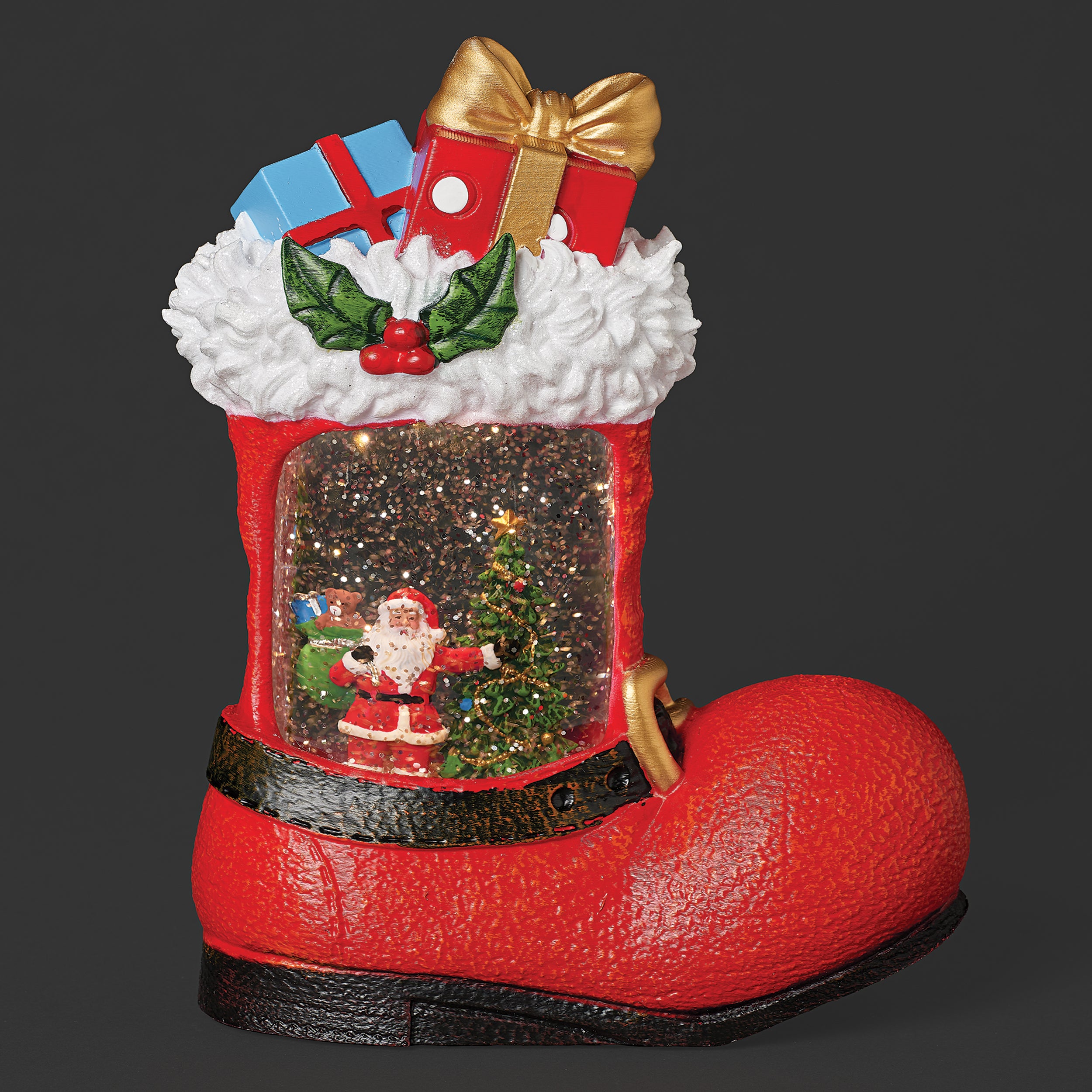 Red Christmas boot tabletop piece with santa inside swirling glitter water on black background.