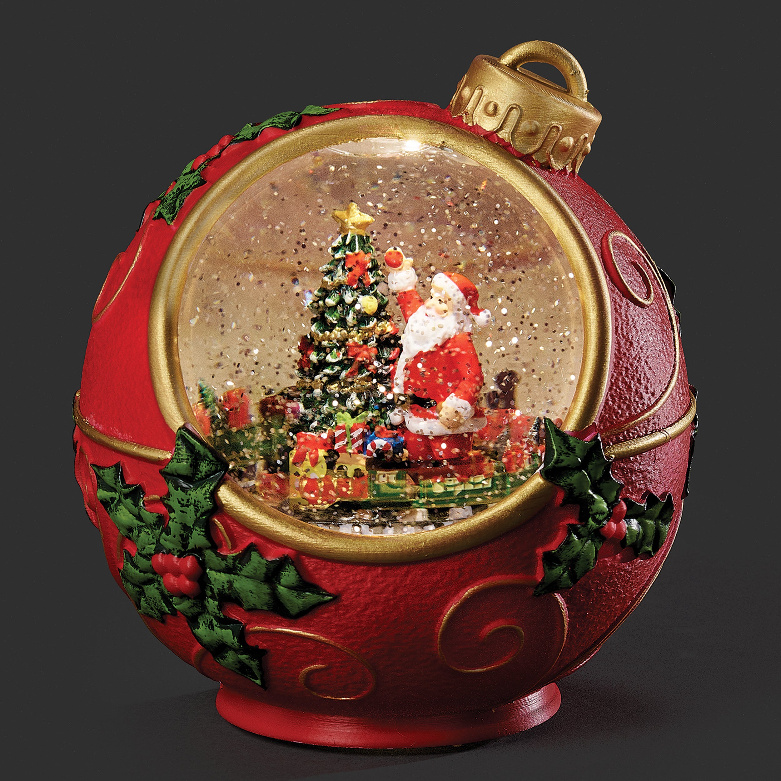Decorative Christmas ornament with Santa Claus and a tree inside a red ball.
