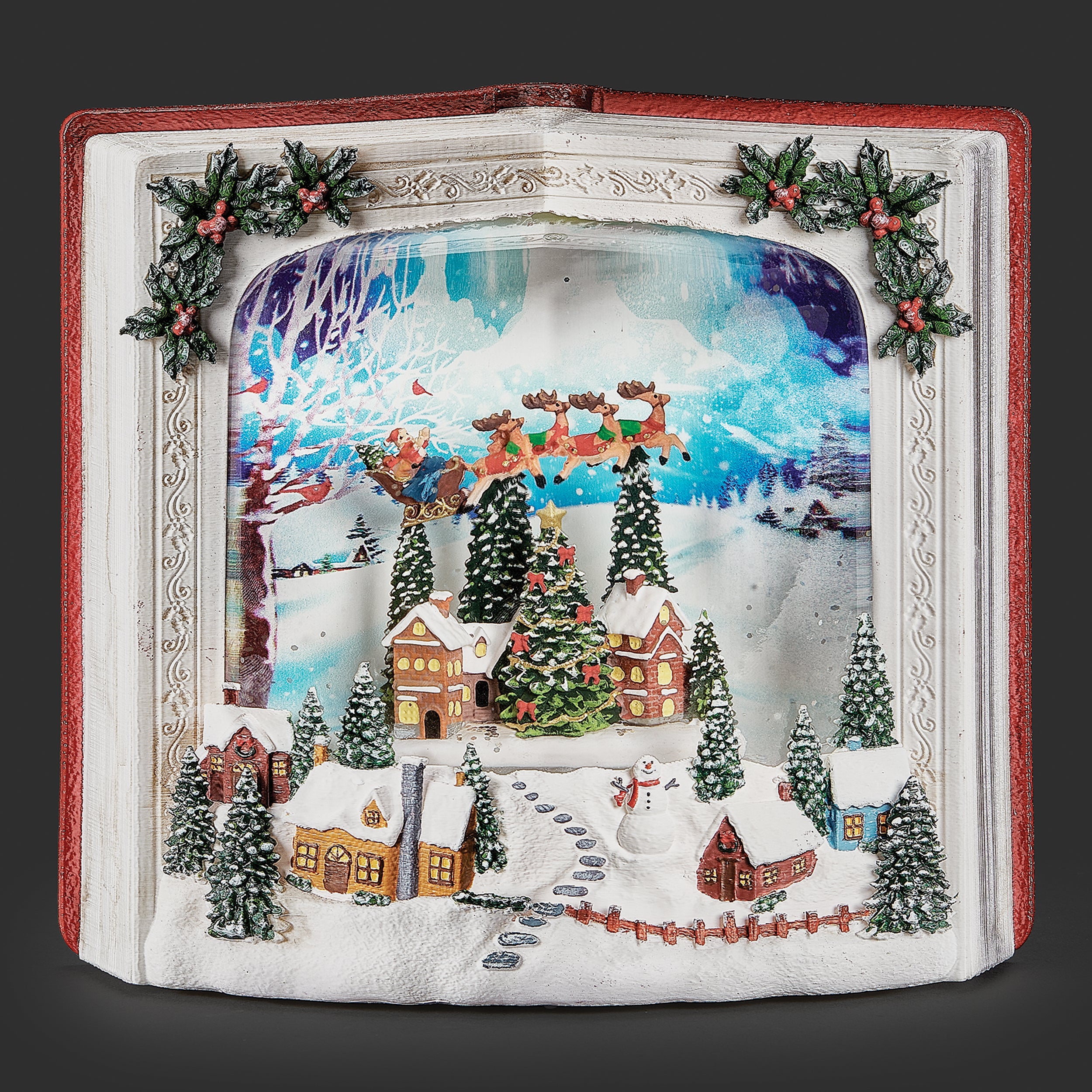 Decorative Christmas book scene with reindeer, houses, and trees in a decorative frame.